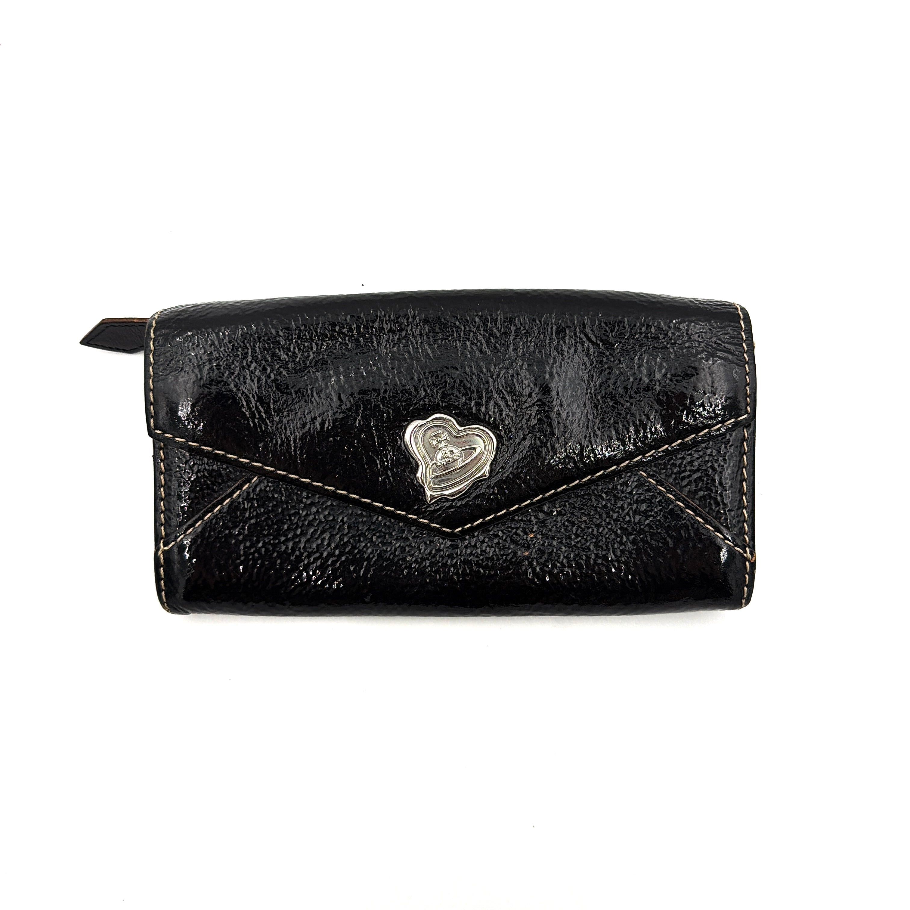 Vivienne Westwood black patent wallet featuring a silver heart orb emblem and envelope flap design.