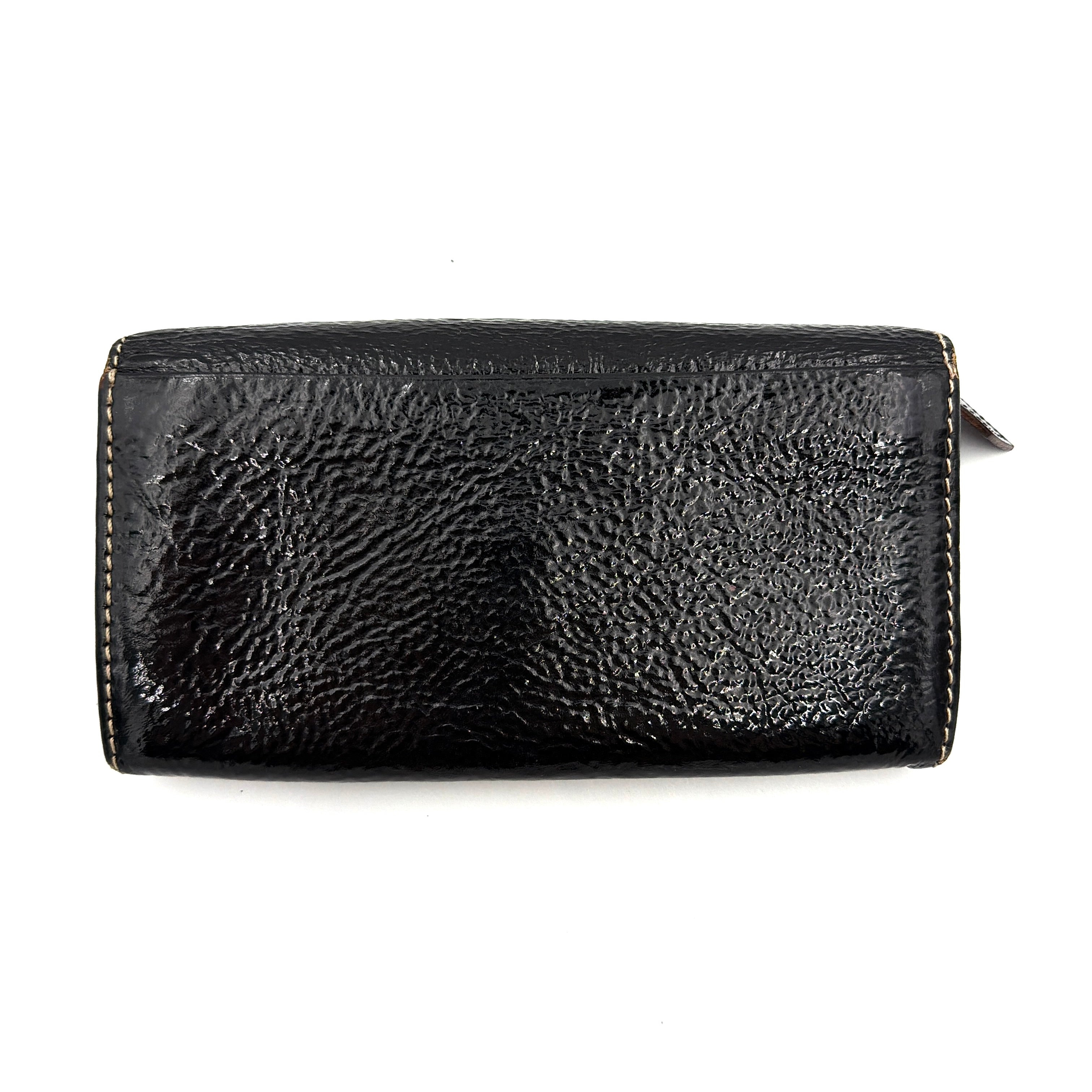 Vivienne Westwood black patent wallet featuring a silver heart orb emblem and envelope flap design.