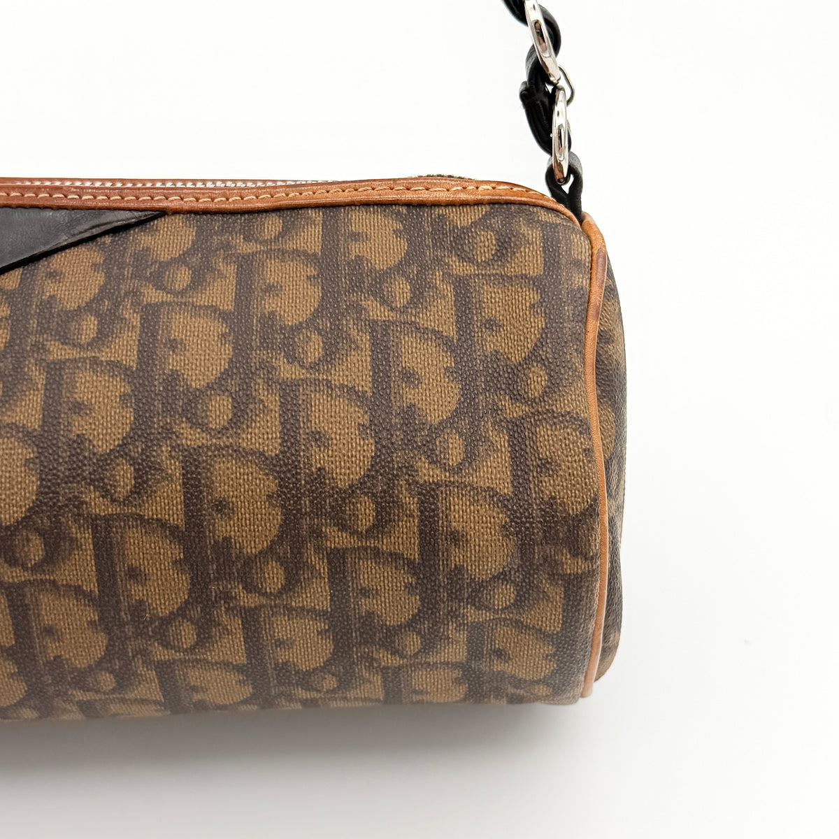 Christian Dior Romantique Heart Trotter mini barrel bag in brown canvas with black leather heart charm and chain-detailed strap.