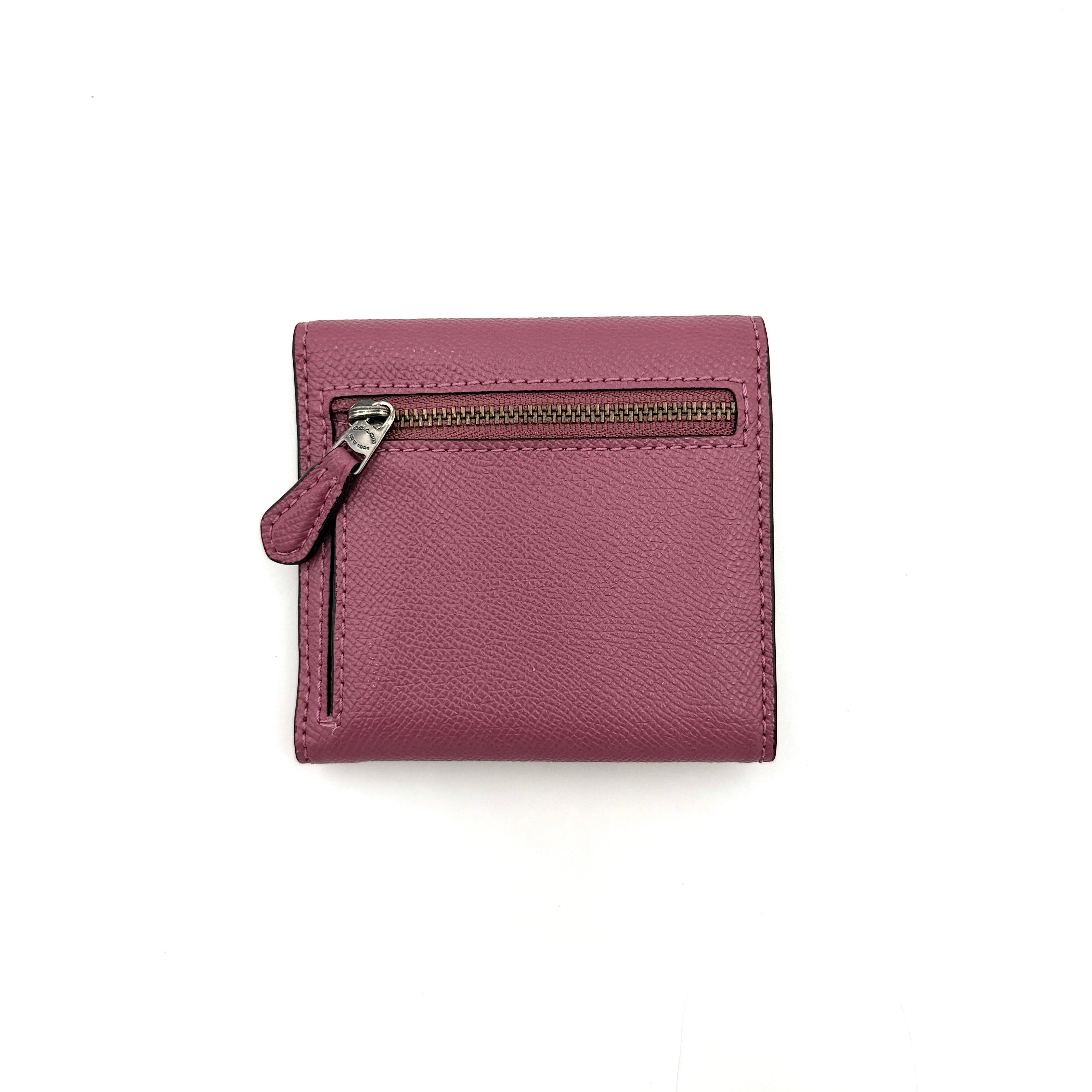 Coach small wallet in pink pebbled leather with silver logo hardware, presented closed and front-facing.