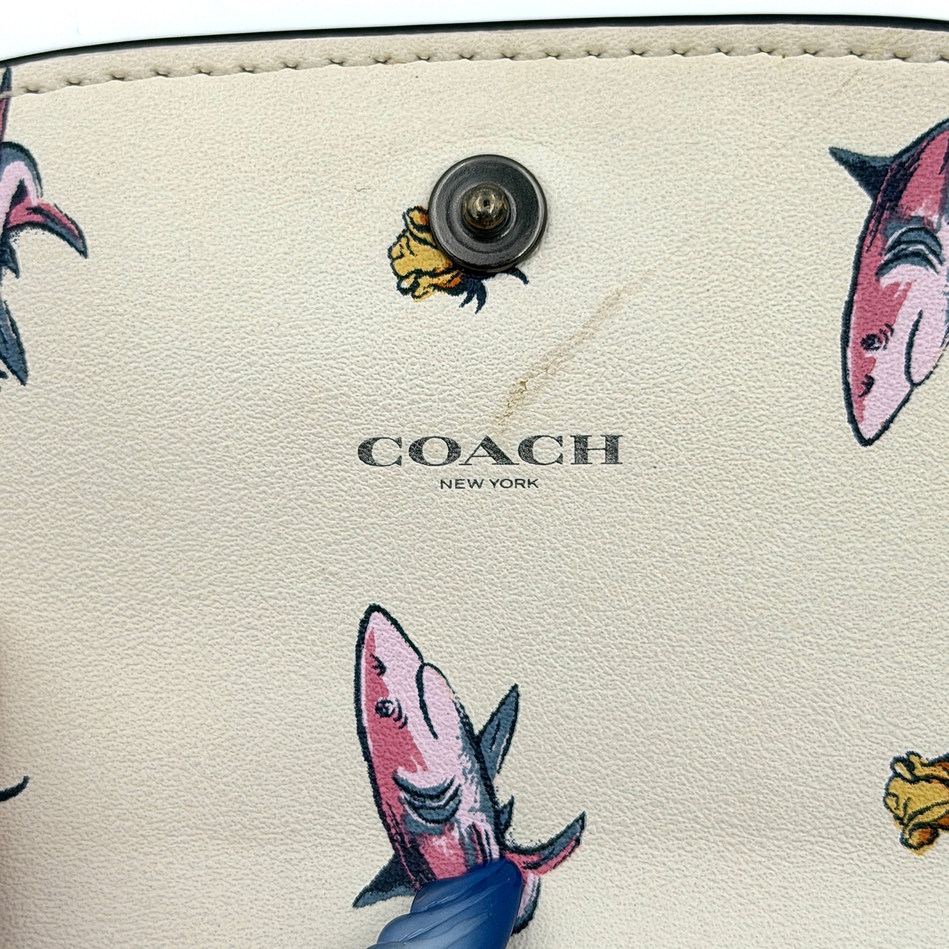 Coach small wallet in pink pebbled leather with silver logo hardware, presented closed and front-facing.