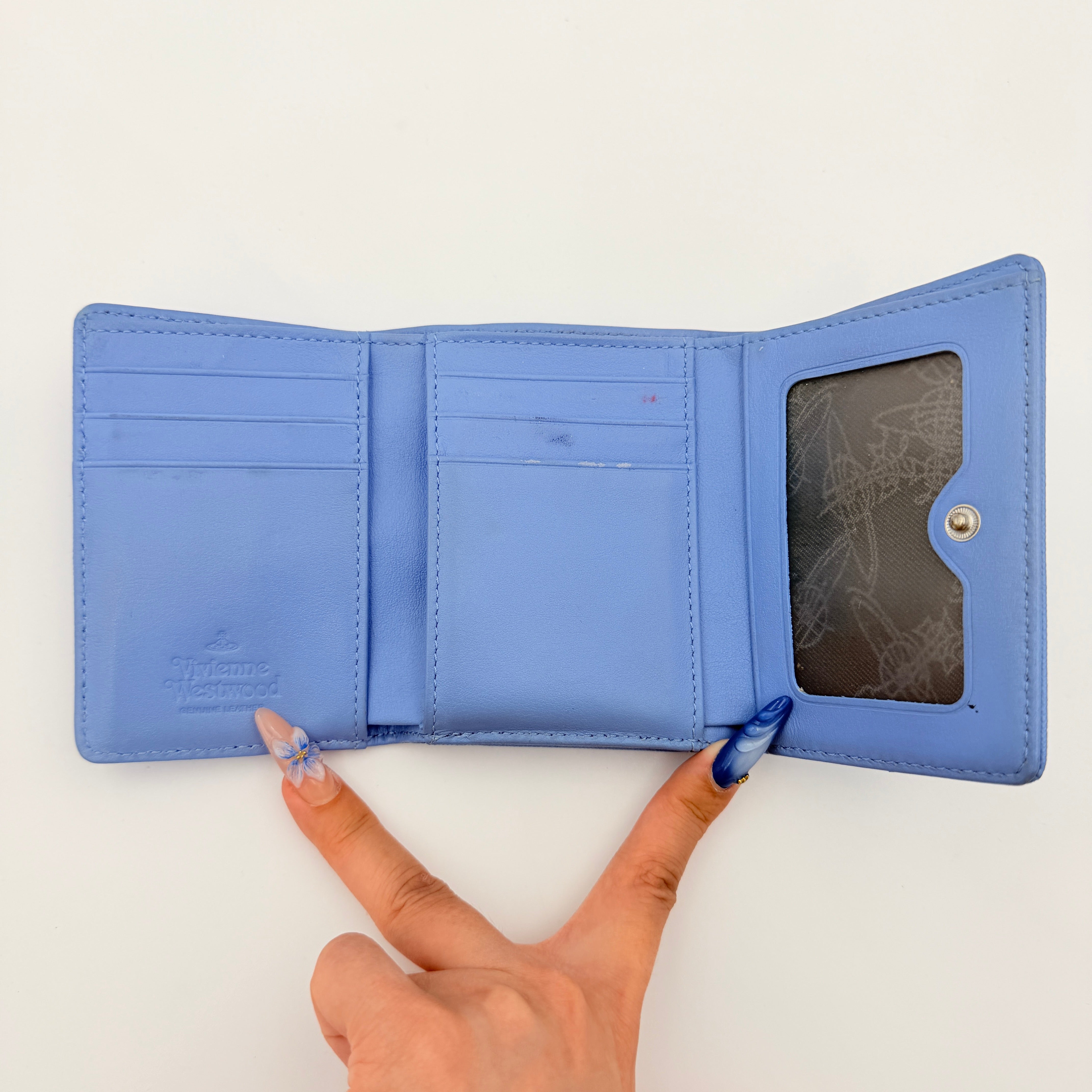 A baby blue leather Vivienne Westwood wallet with silver Orb logo and structured silhouette, photographed against a clean background.