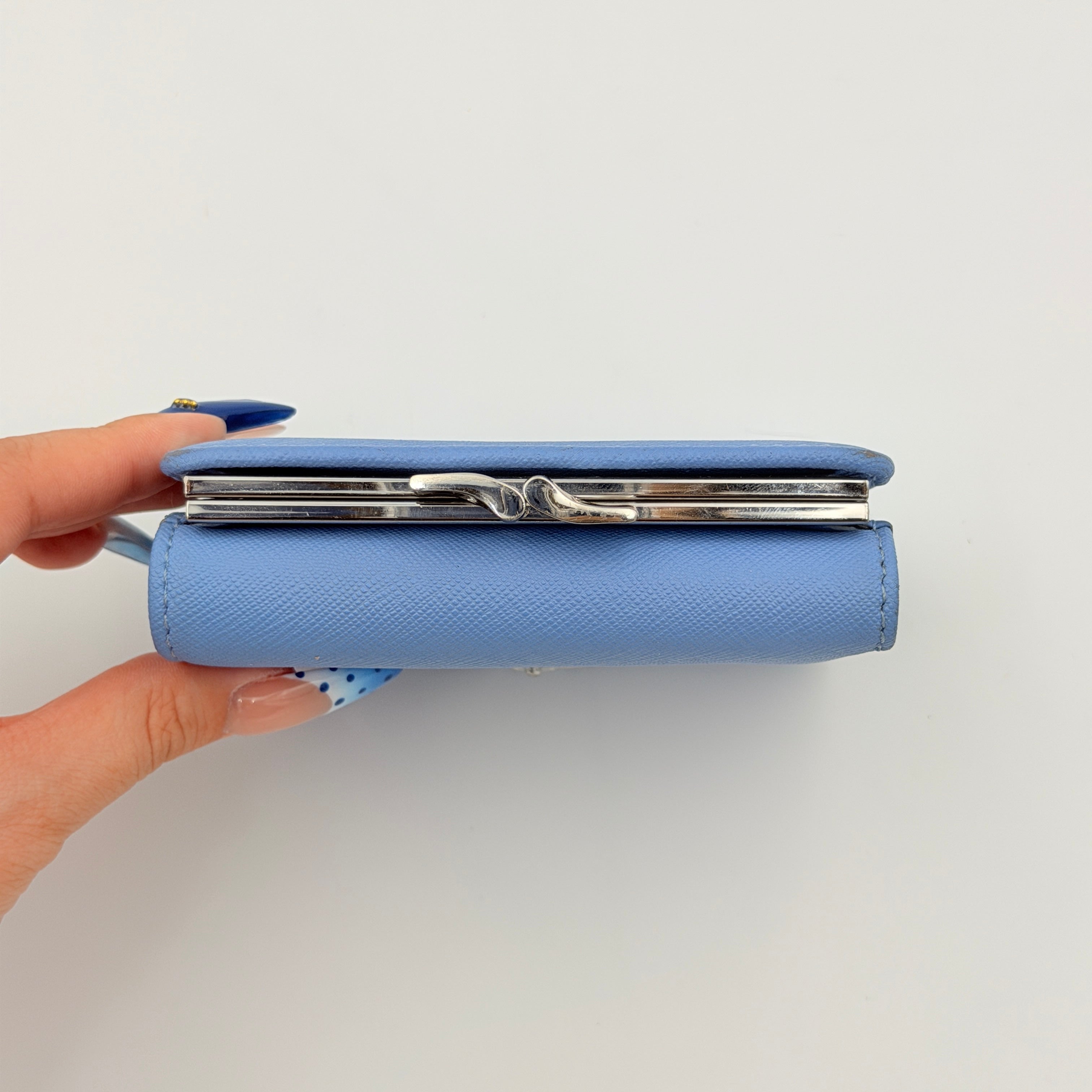 A baby blue leather Vivienne Westwood wallet with silver Orb logo and structured silhouette, photographed against a clean background.
