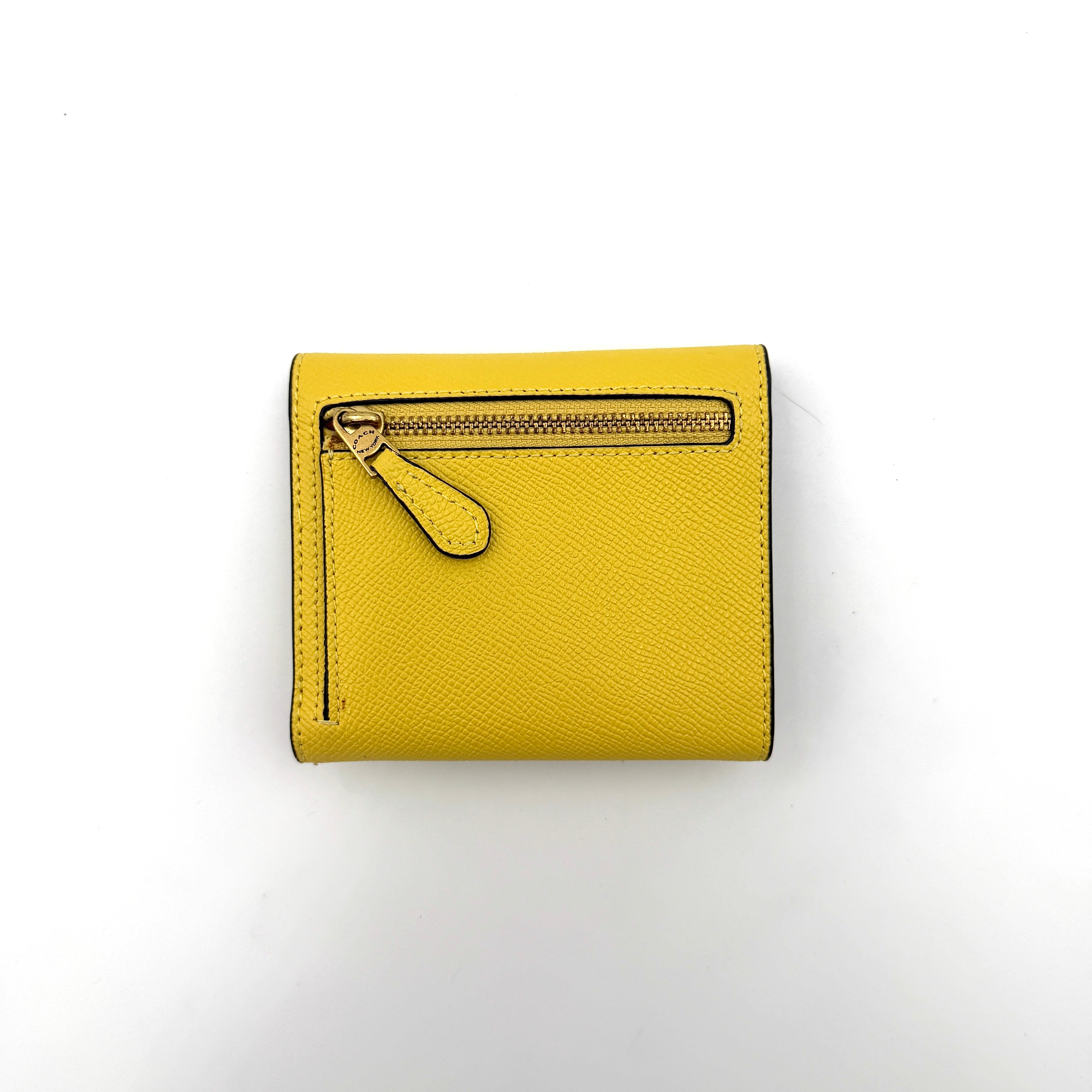 Coach Wyn Small Wallet in vibrant yellow leather with gold-tone 'C' detail on the envelope flap.