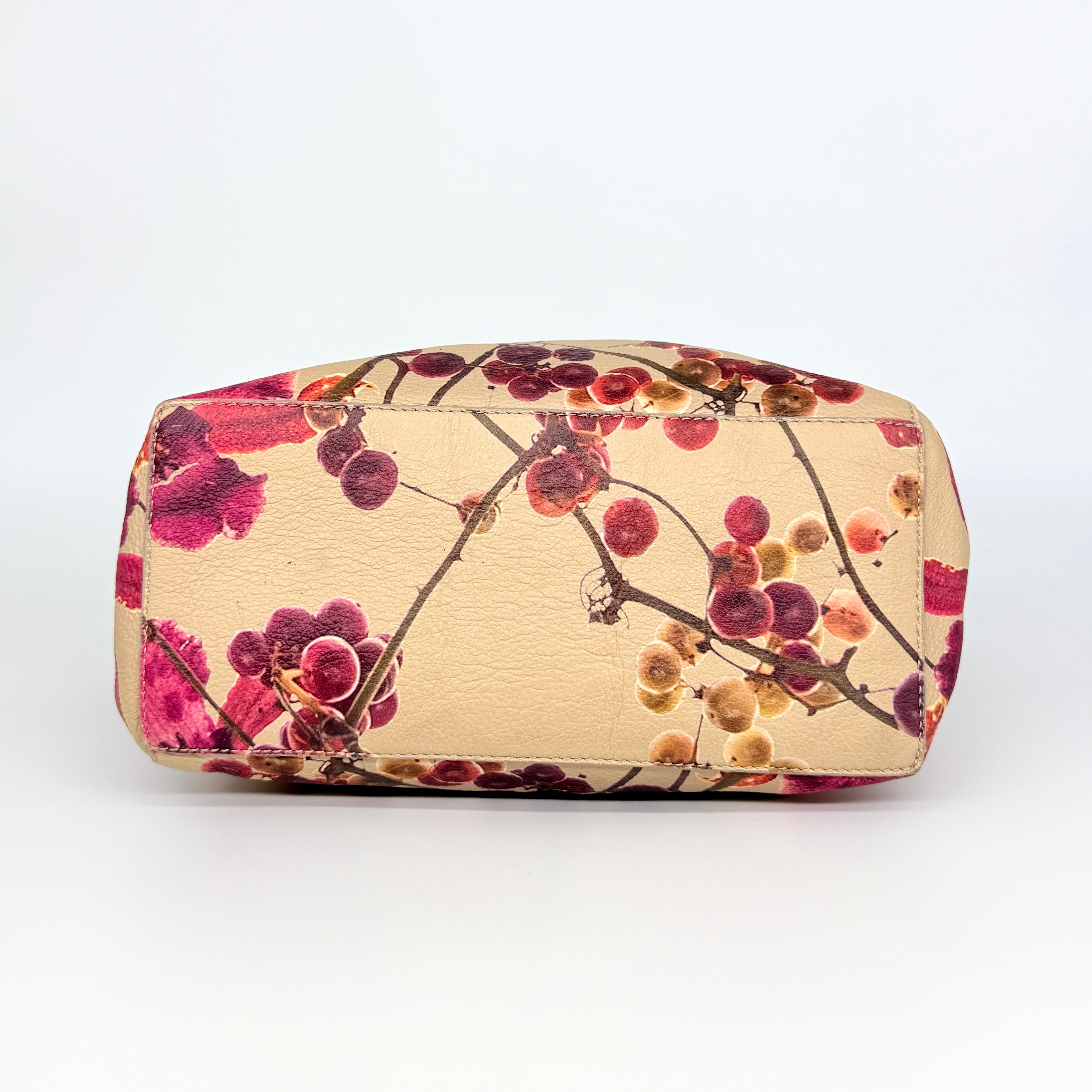 Furla beige leather tote bag adorned with a bold magenta and plum floral print, featuring structured short handles.