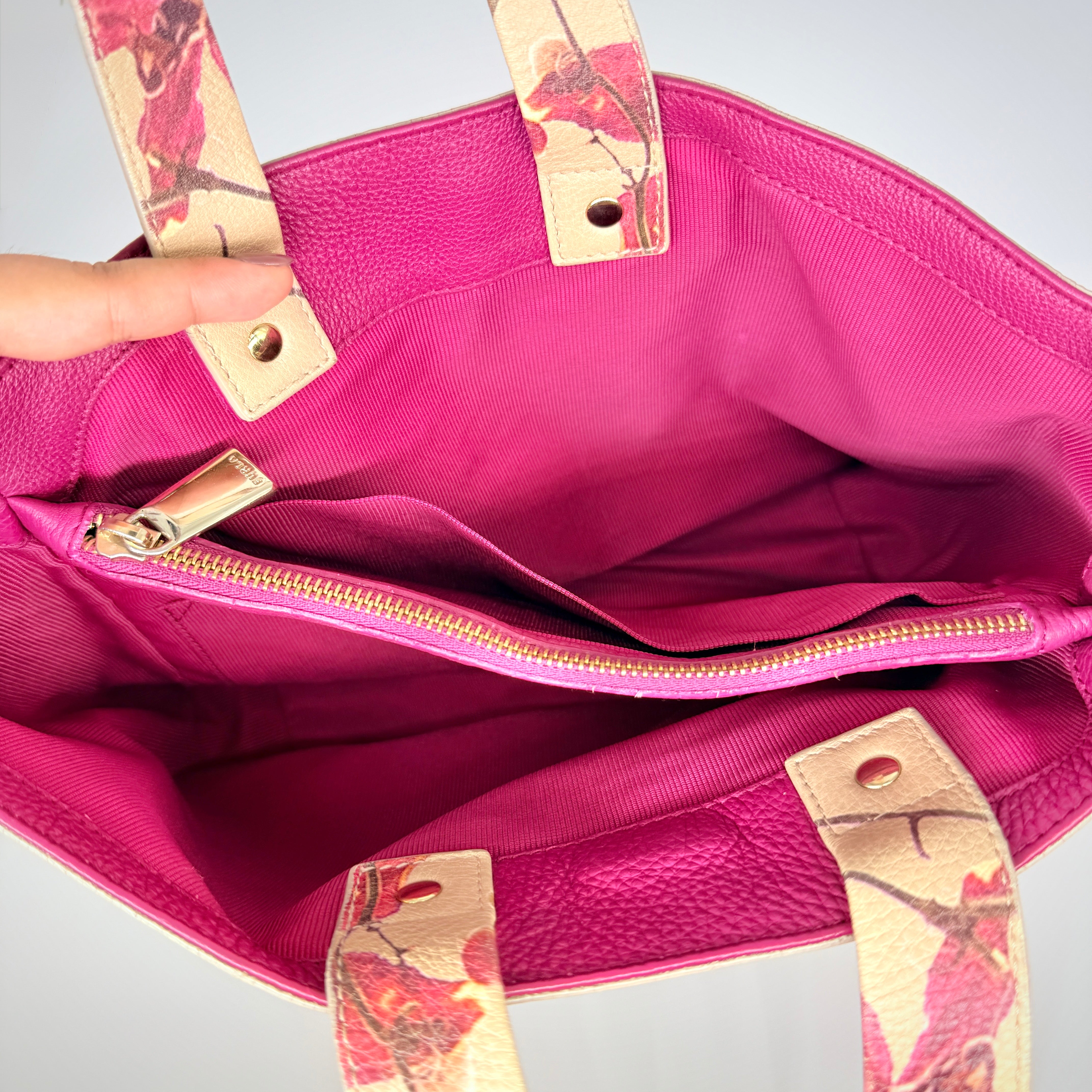 Furla beige leather tote bag adorned with a bold magenta and plum floral print, featuring structured short handles.
