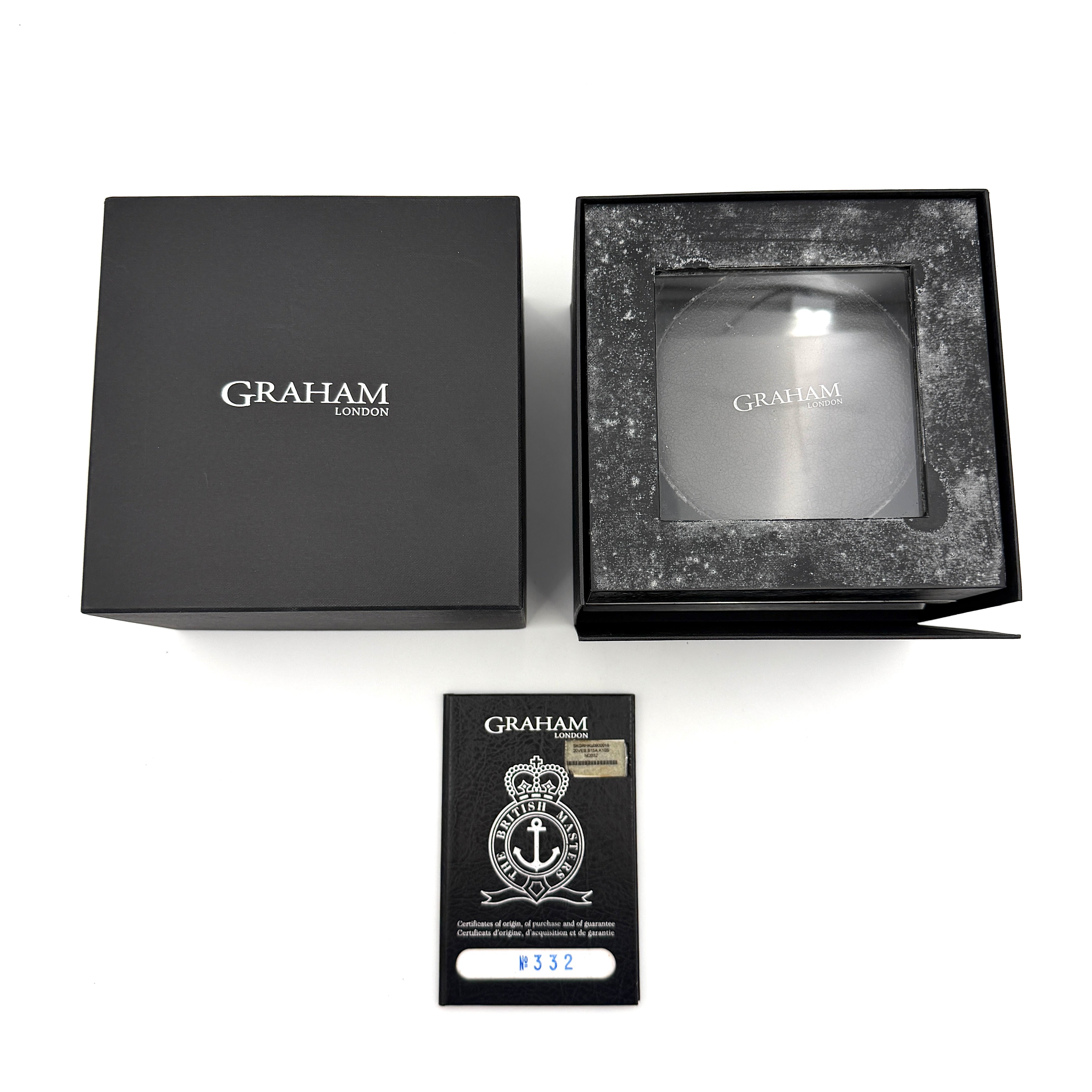 The Graham Chronofighter Oversize Diver 2OVES.B15A watch displayed in its signature round Graham London presentation case, showcasing its bold black dial, prominent chronograph trigger, and black rubber strap.