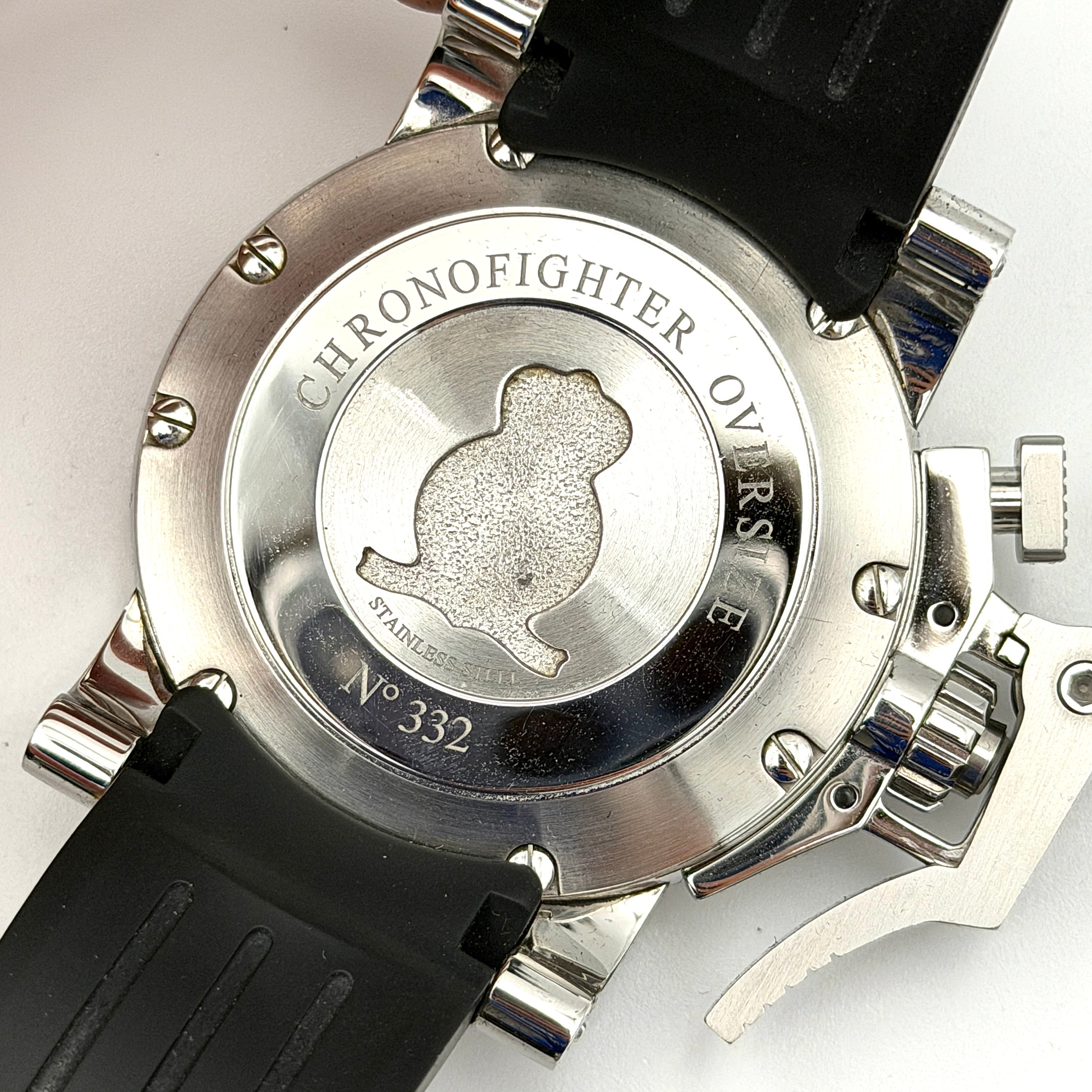 The Graham Chronofighter Oversize Diver 2OVES.B15A watch displayed in its signature round Graham London presentation case, showcasing its bold black dial, prominent chronograph trigger, and black rubber strap.