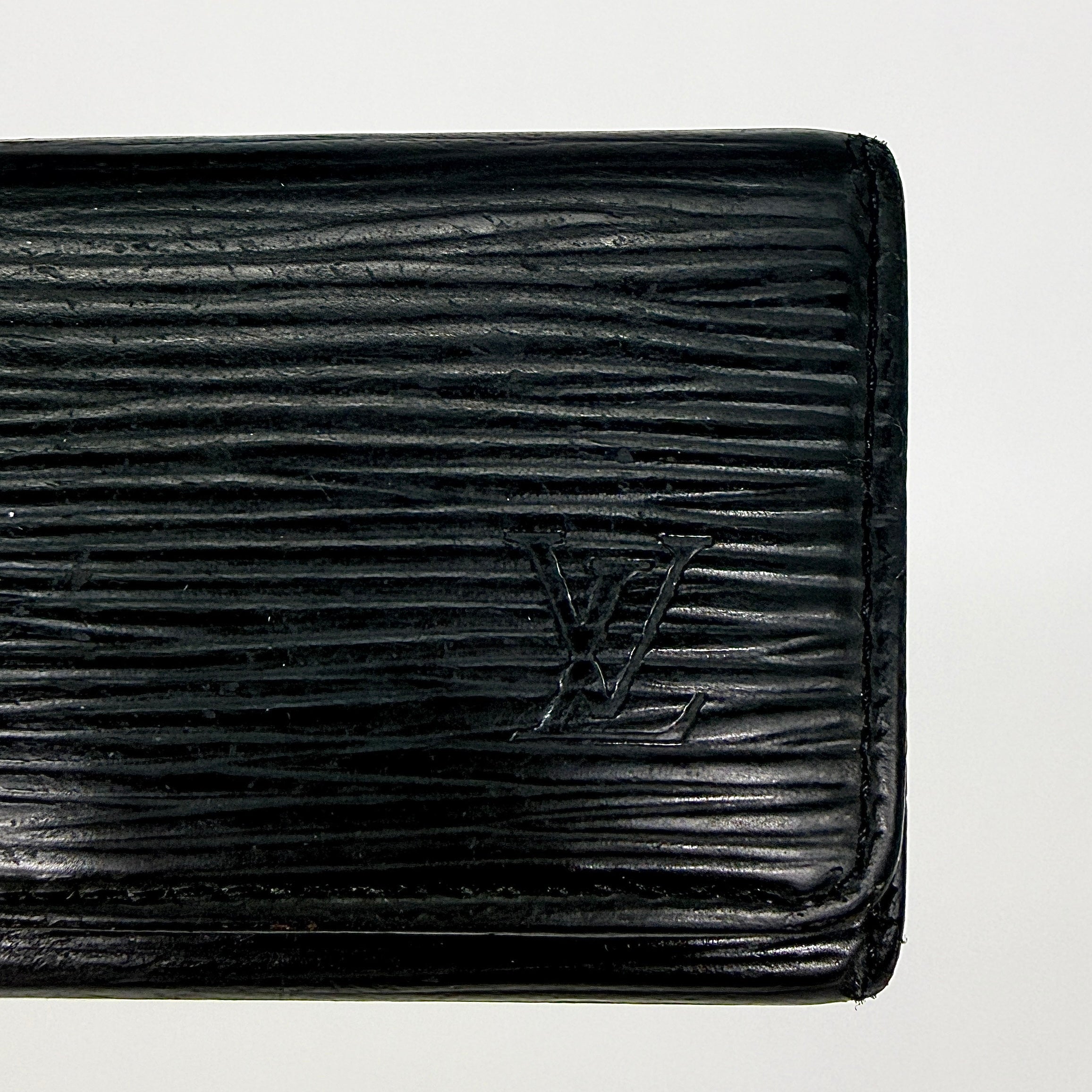 Louis Vuitton Epi Leather key case in black with silver-tone key hooks and snap closure, photographed against a clean white background.