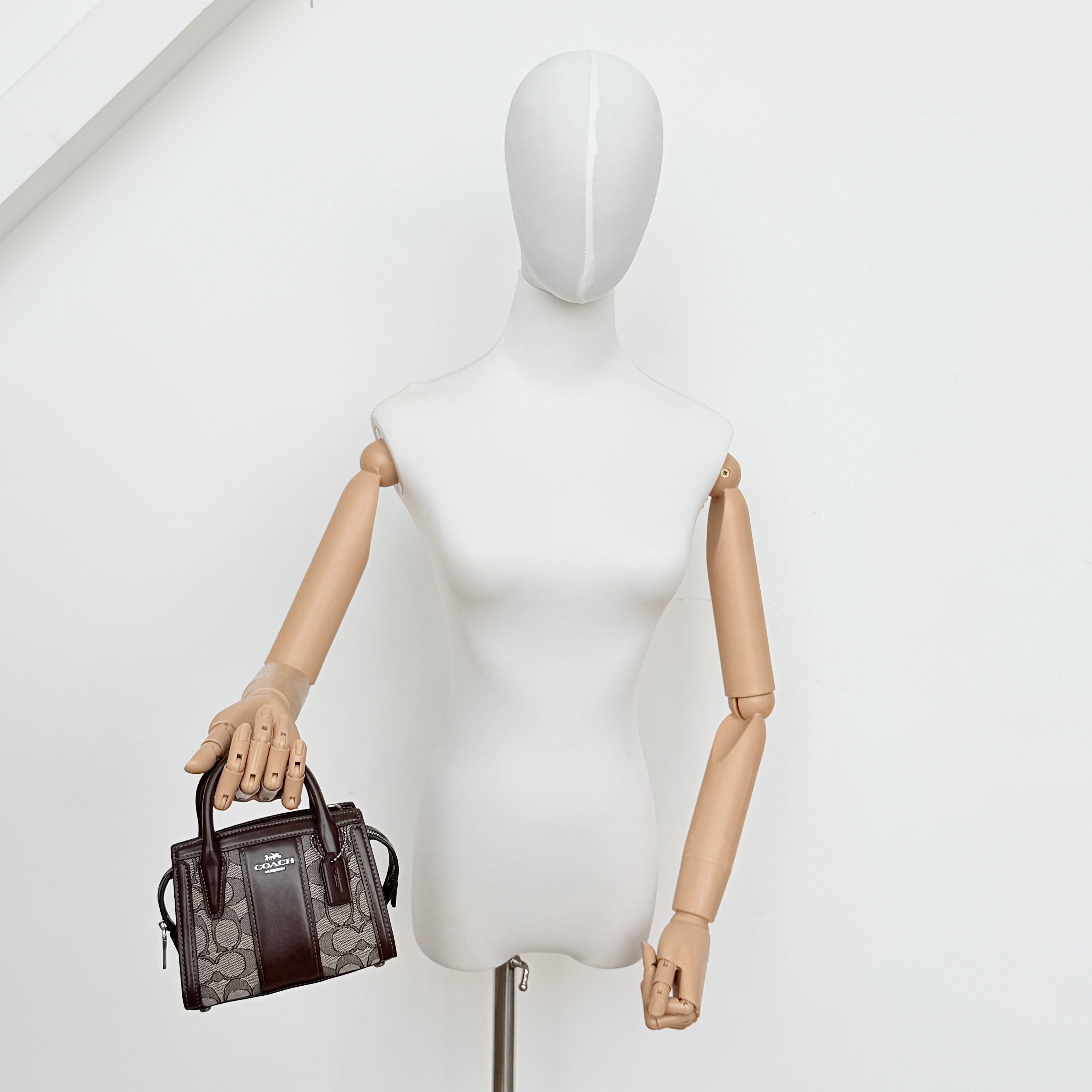 Front view of the Coach Signature Mini Andrea Carryall Shoulder Bag in brown canvas and leather with silver hardware.