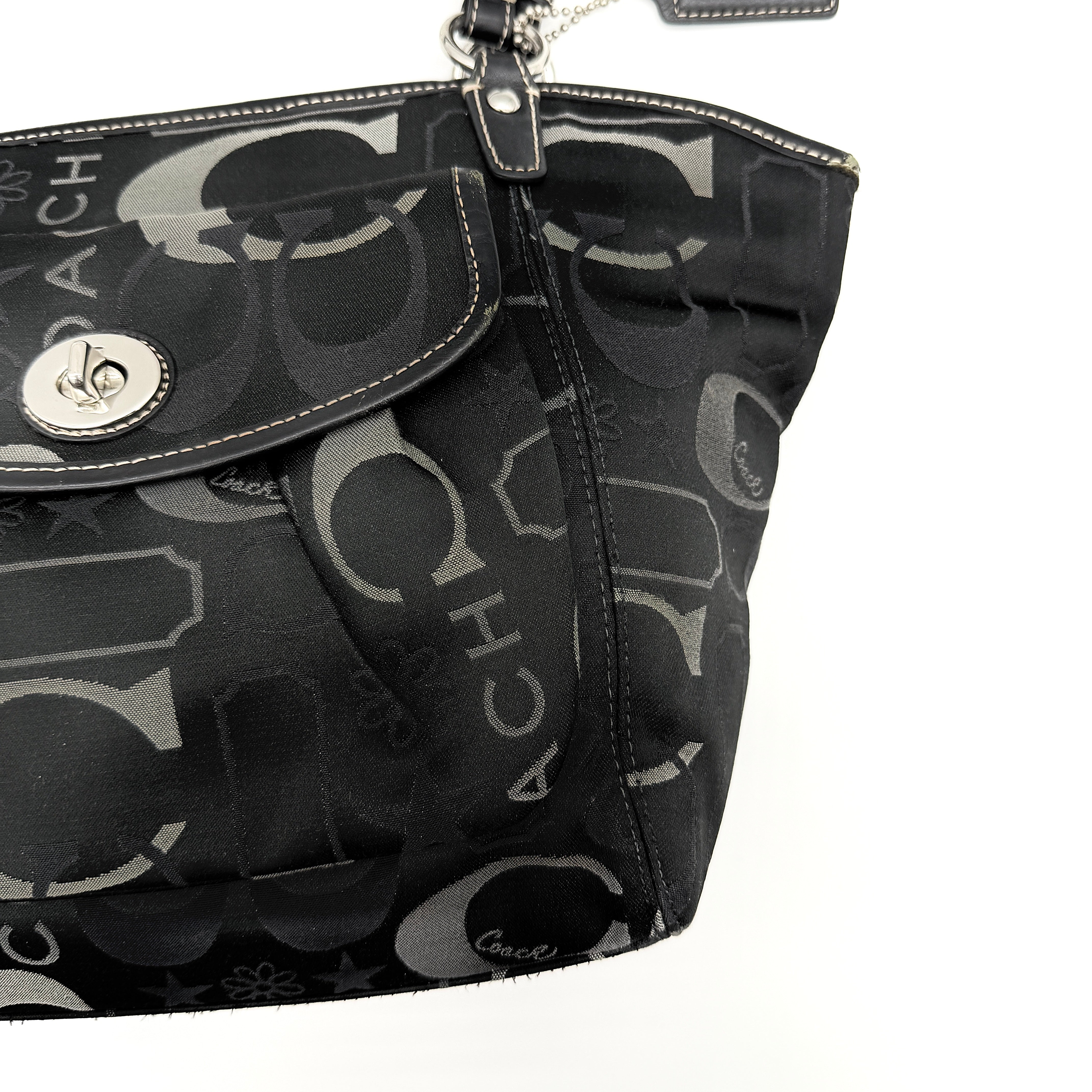 Coach Signature Leah Shoulder Bag in black jacquard with silver-tone hardware and bold logo pattern.