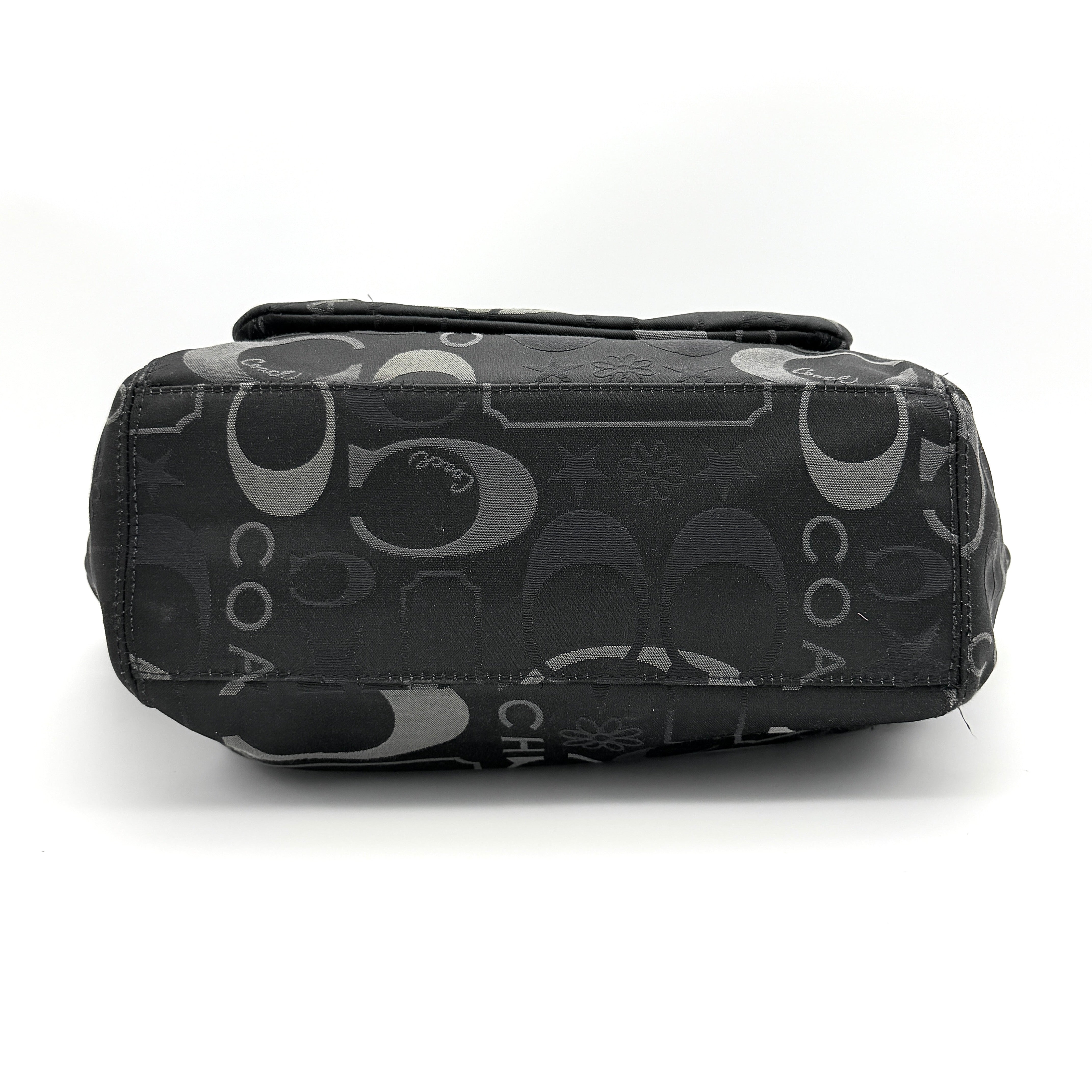 Coach Signature Leah Shoulder Bag in black jacquard with silver-tone hardware and bold logo pattern.