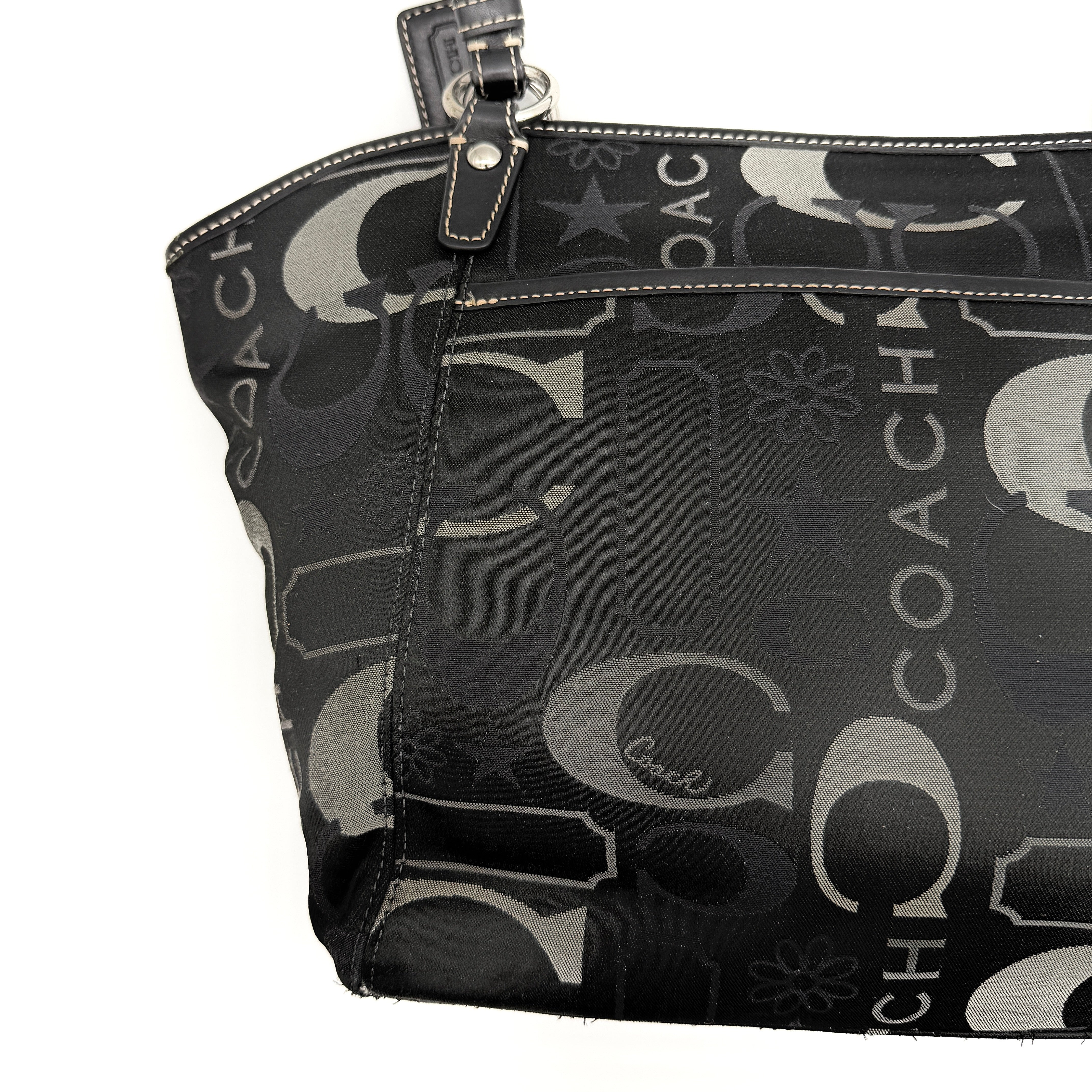 Coach Signature Leah Shoulder Bag in black jacquard with silver-tone hardware and bold logo pattern.
