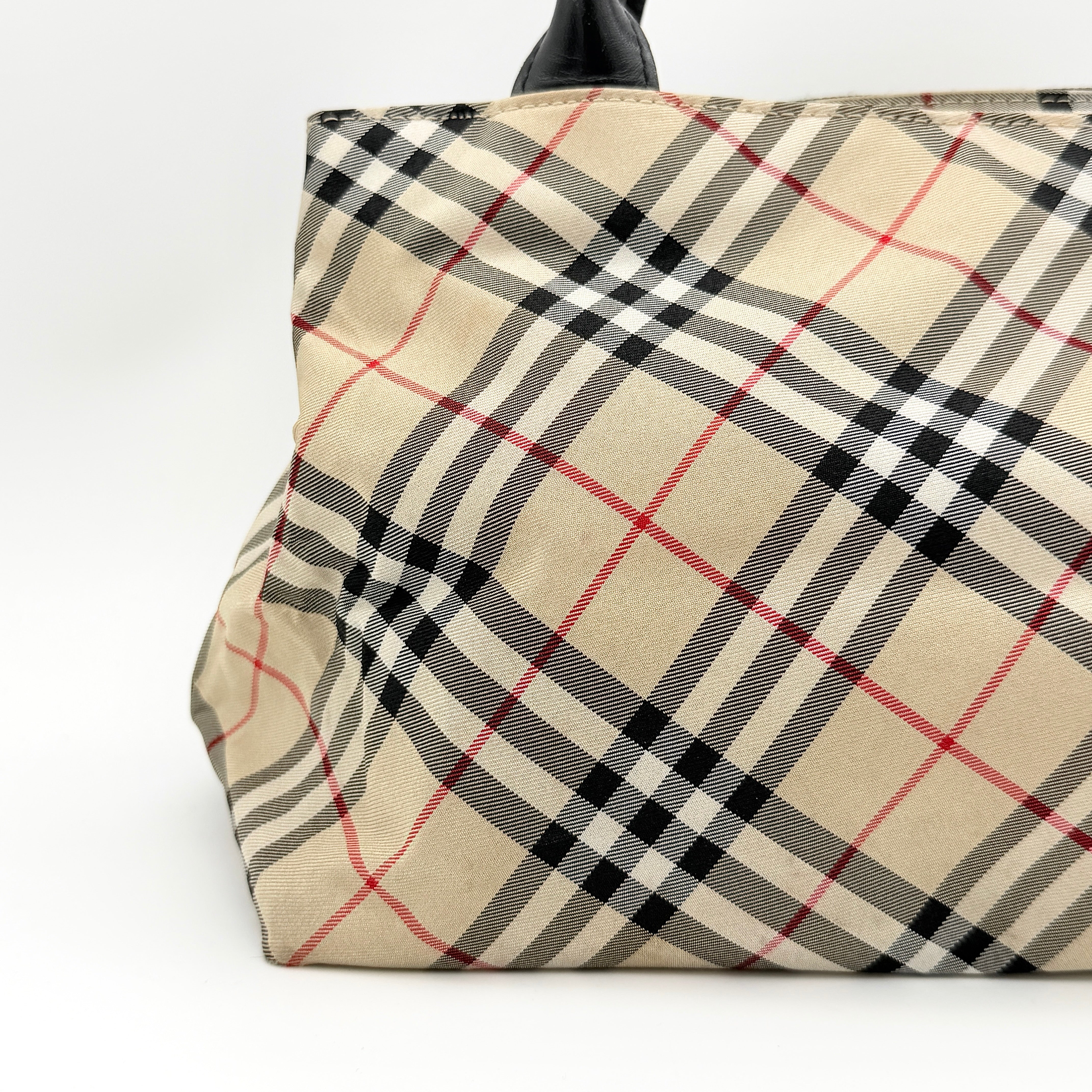 Burberry Blue Label Nova Check nylon shoulder bag in beige and black with leather handles, displayed against a white background.