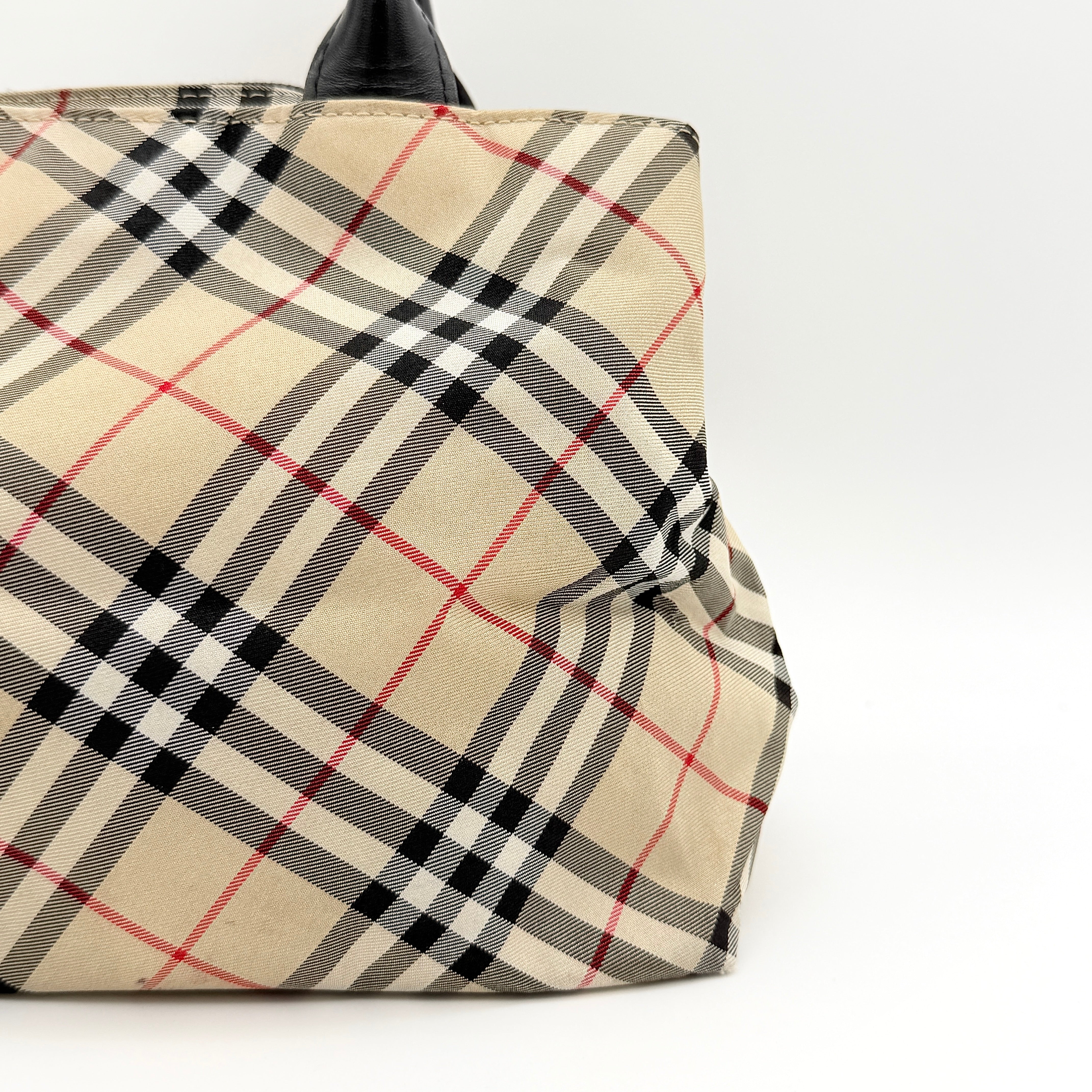 Burberry Blue Label Nova Check nylon shoulder bag in beige and black with leather handles, displayed against a white background.