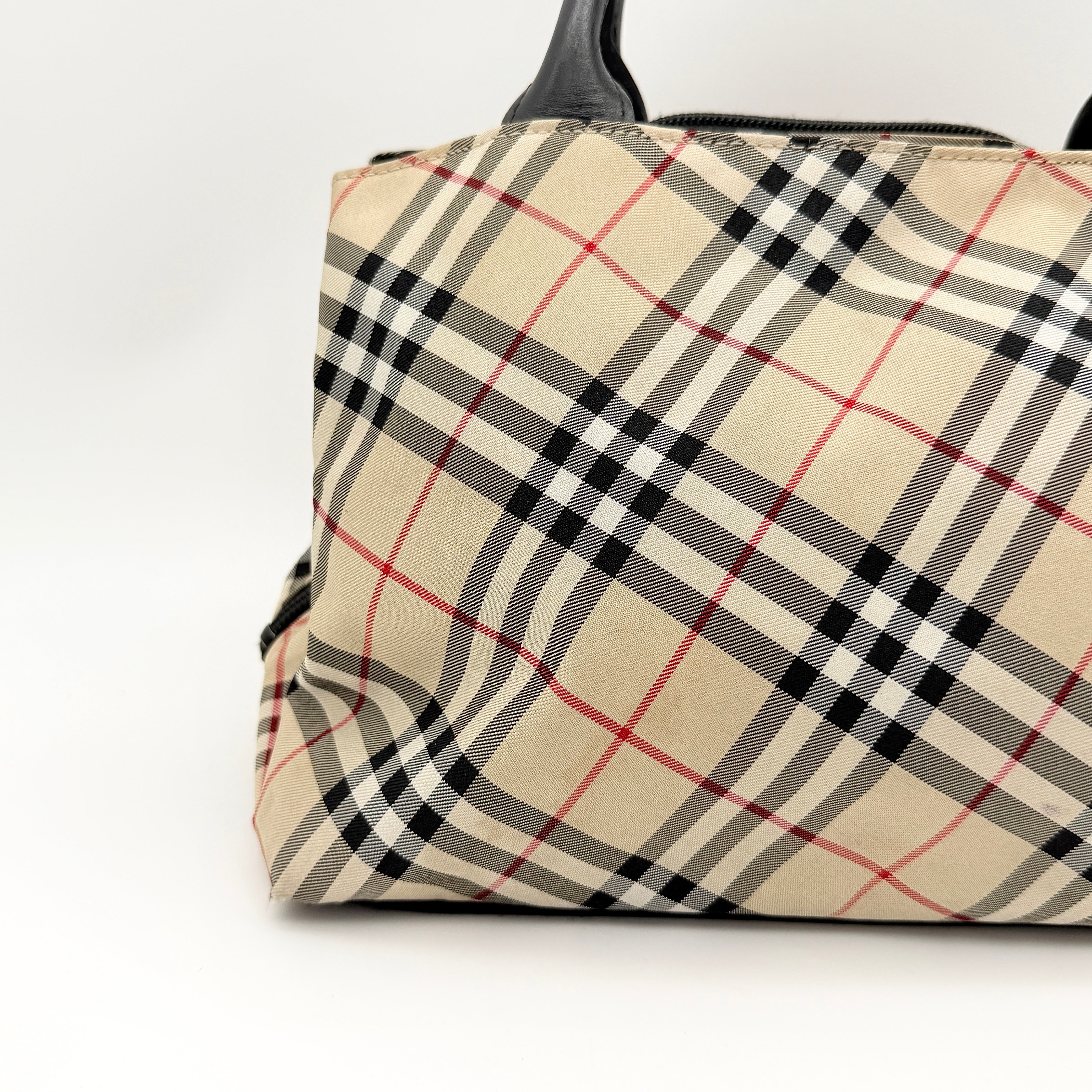 Burberry Blue Label Nova Check nylon shoulder bag in beige and black with leather handles, displayed against a white background.