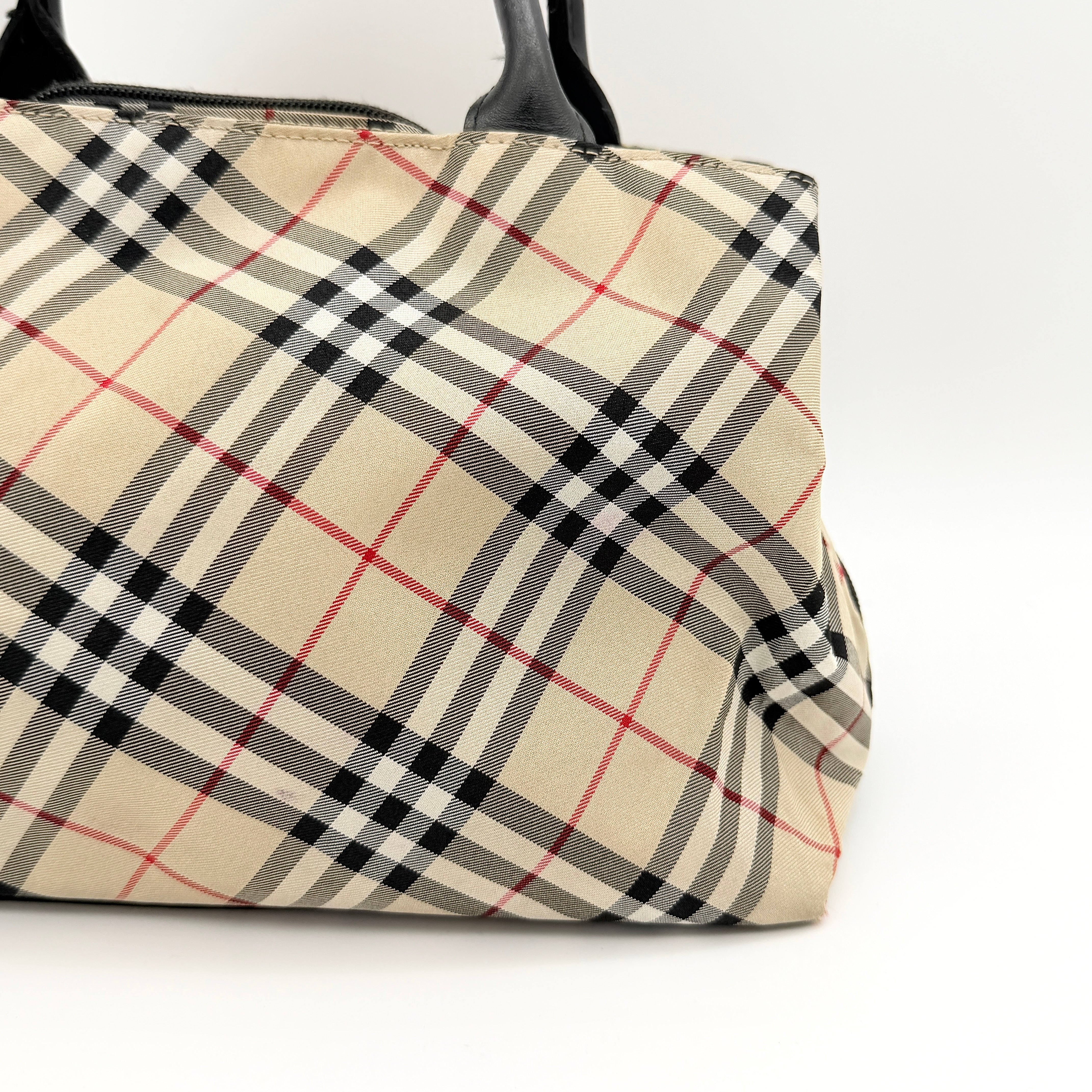 Burberry Blue Label Nova Check nylon shoulder bag in beige and black with leather handles, displayed against a white background.
