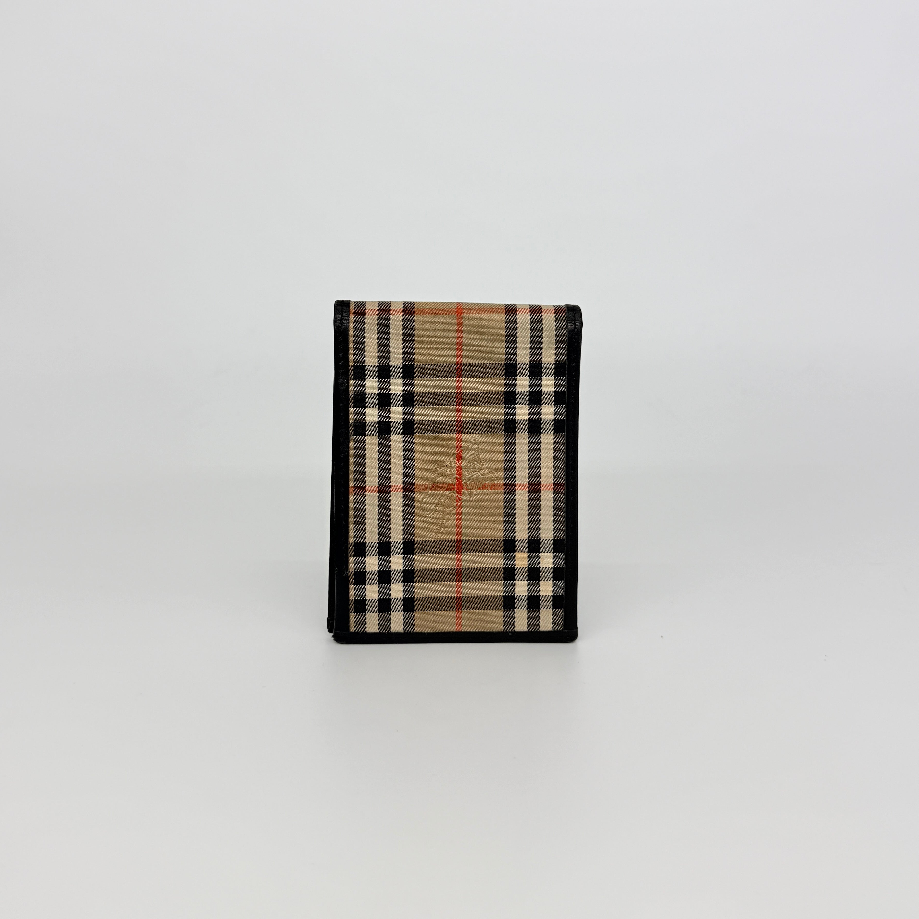 Front-facing view of a Burberry Nova Check cardholder in beige canvas with black leather trim and an oval Burberrys plaque.