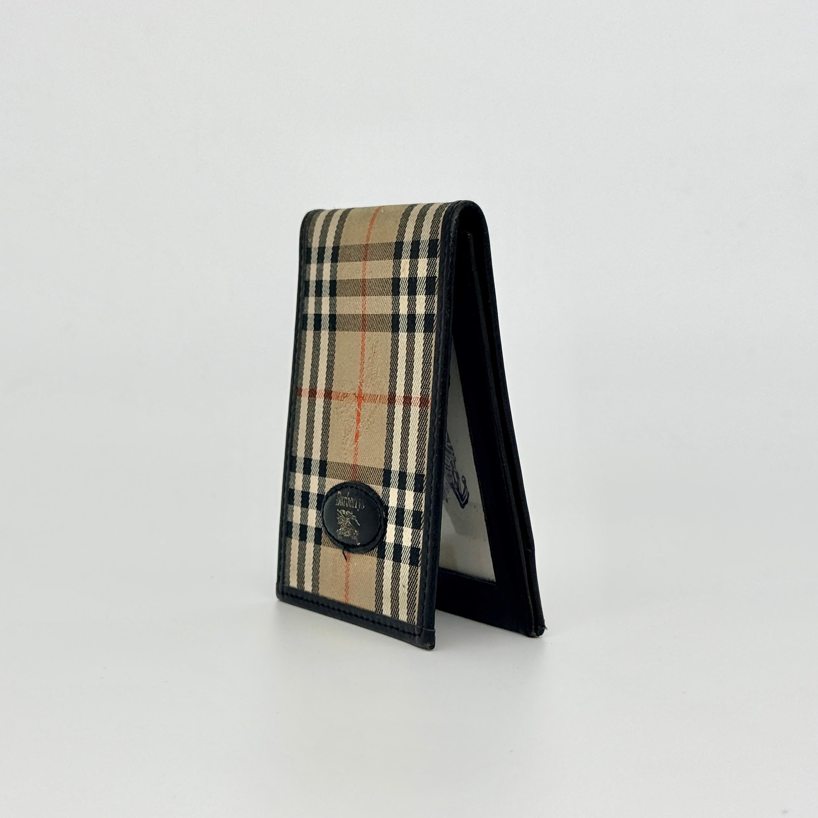 Front-facing view of a Burberry Nova Check cardholder in beige canvas with black leather trim and an oval Burberrys plaque.