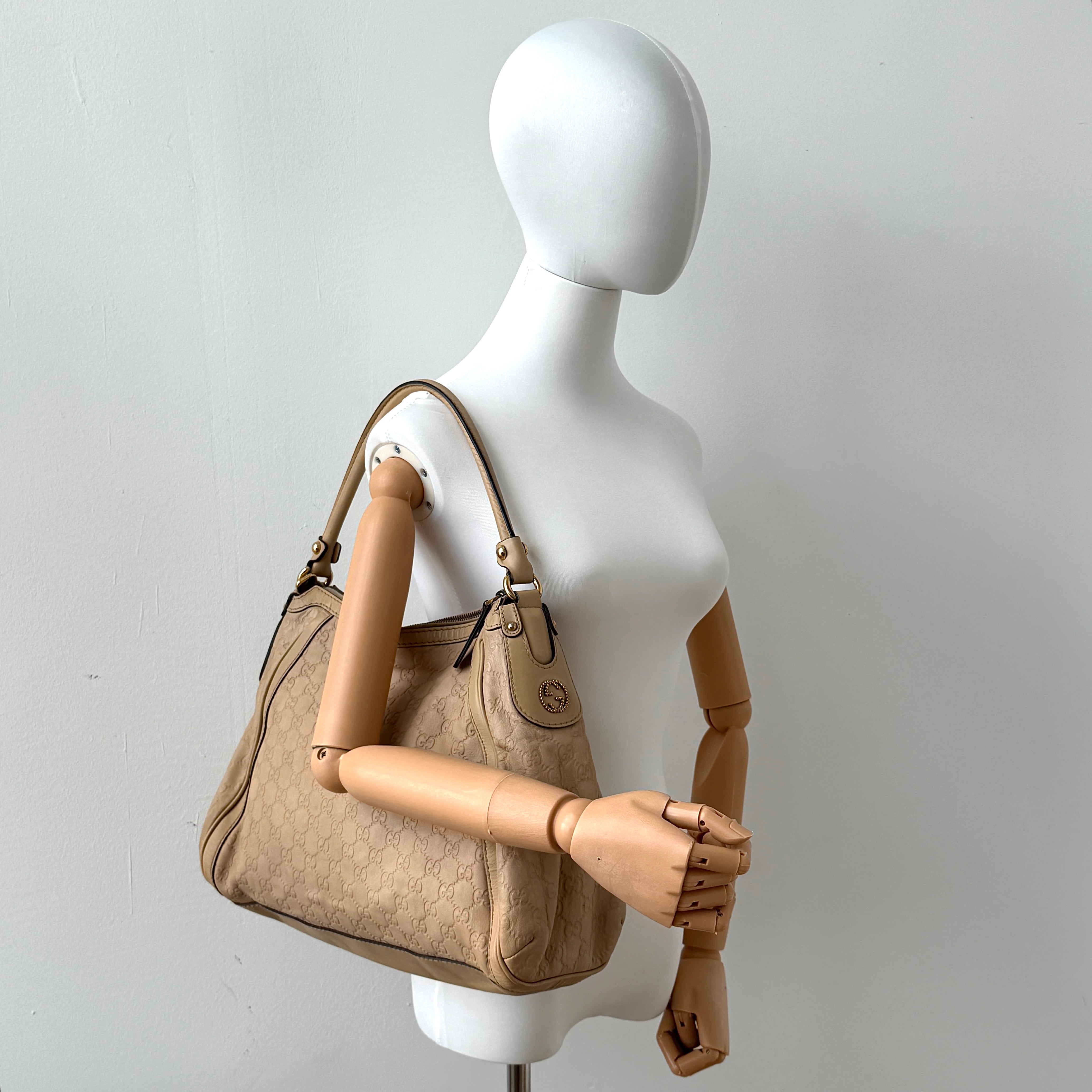 Gucci GG Monogram Guccissima Scarlett Shoulder Bag in beige embossed leather with gold hardware and single top handle.