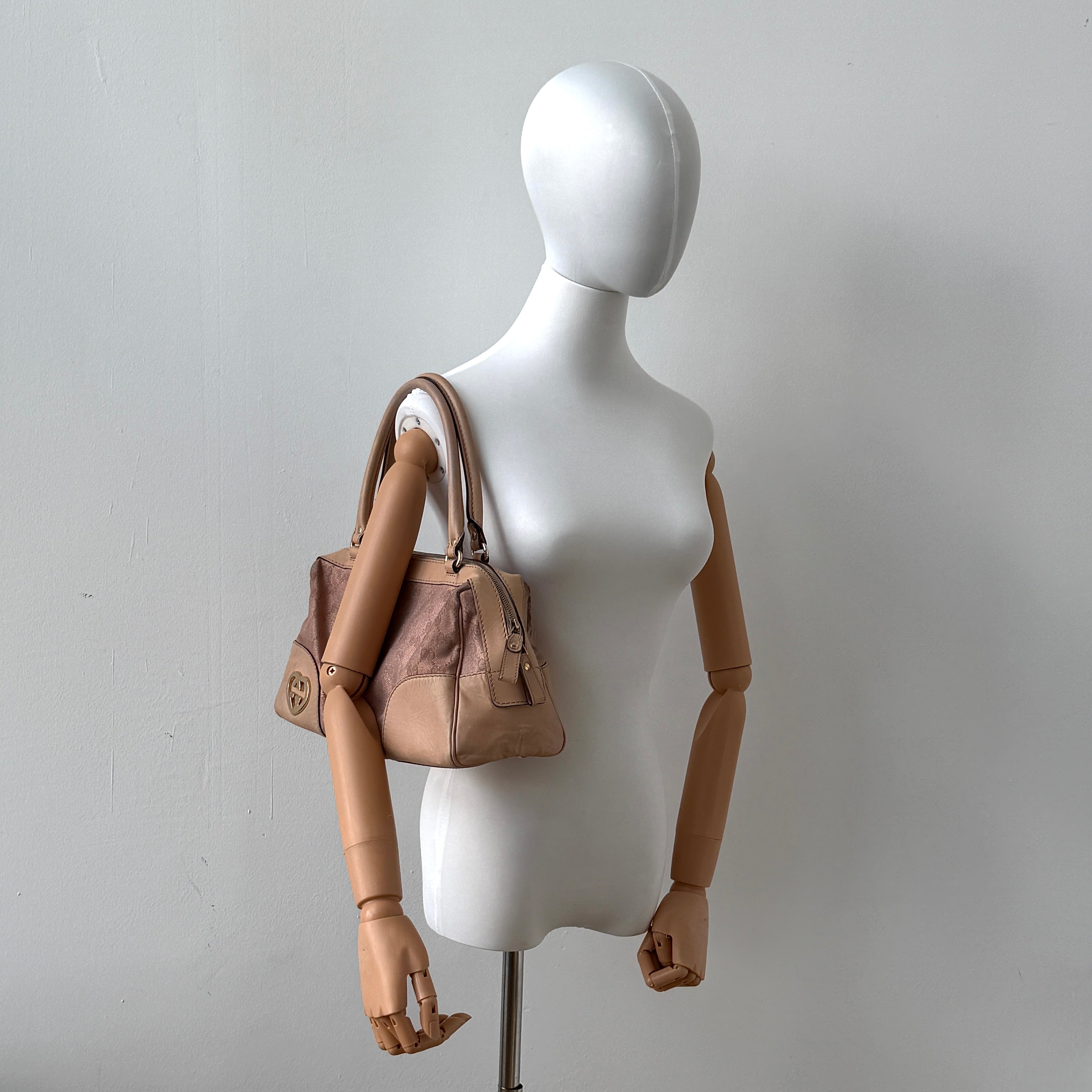 Gucci GG Monogram Heart Lovely Boston Bag in beige and pink with gold heart logo and double handles, displayed against a plain background.