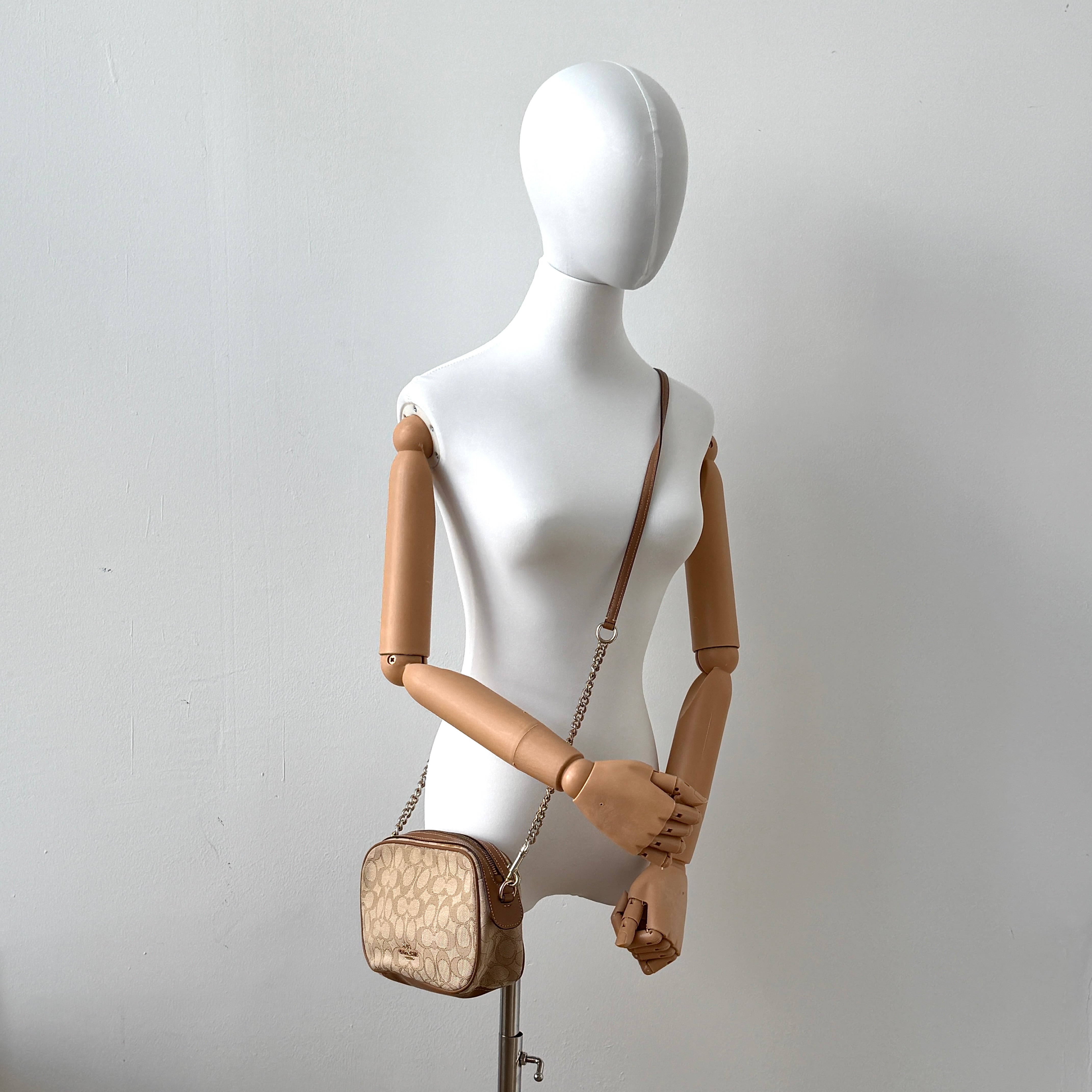 Coach Signature Isla Chain Crossbody Bag in beige and brown jacquard with caramel leather trim and gold-tone chain strap.