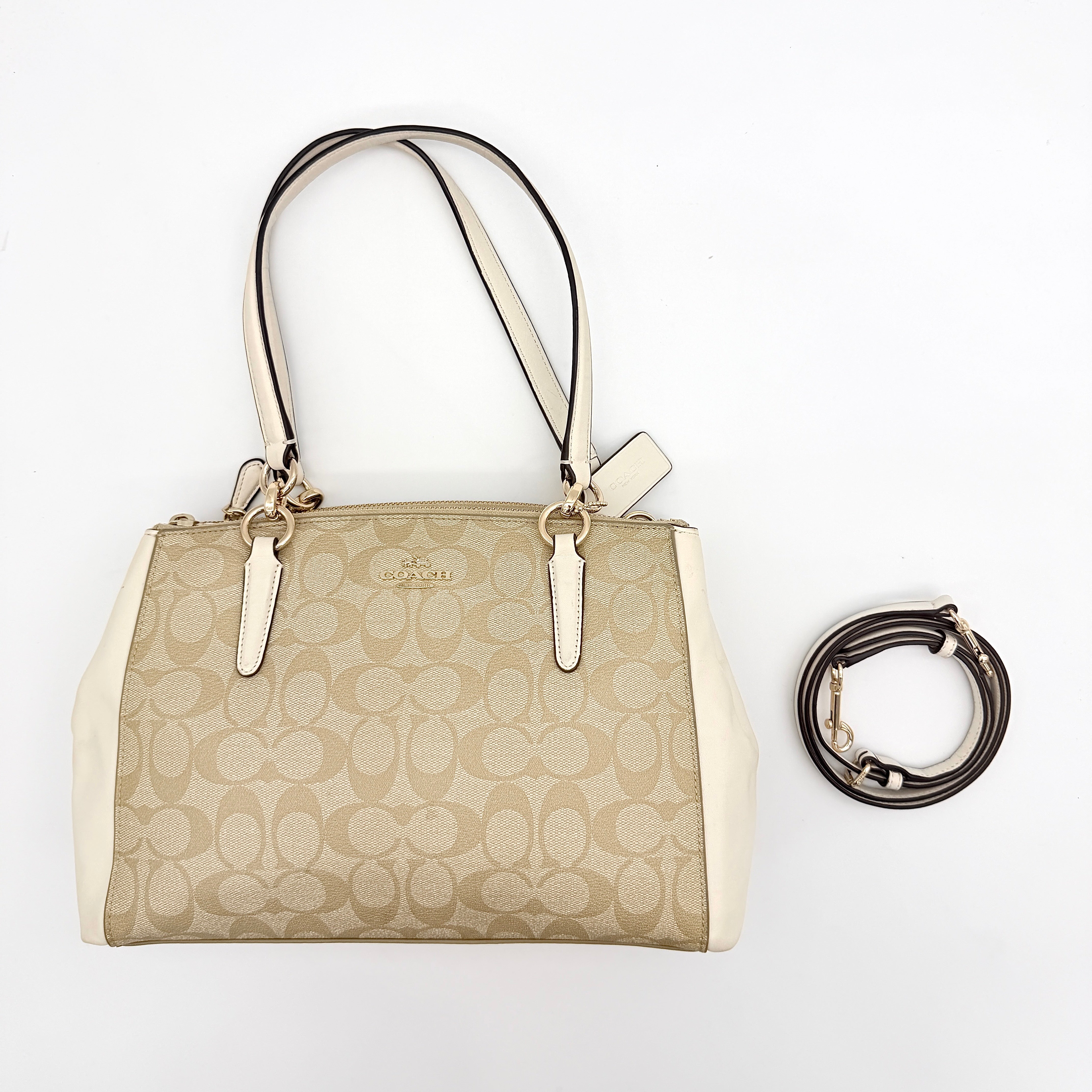 Coach Signature Christie Carryall in beige jacquard with white leather panels, double handles, and detachable strap.