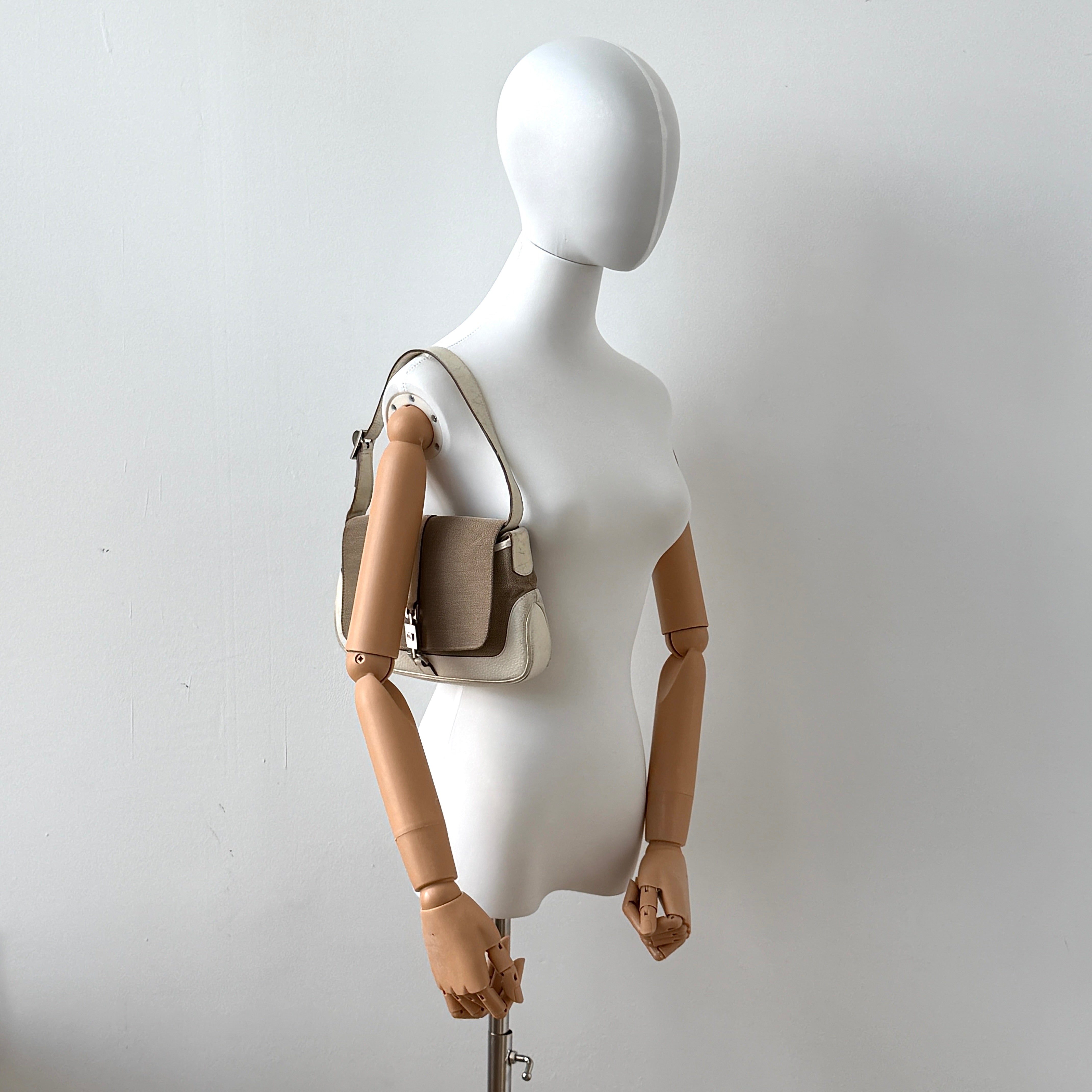 Gucci Jackie Shoulder Bag in brown canvas and white leather trim with silver-tone hardware, displayed against a clean background.