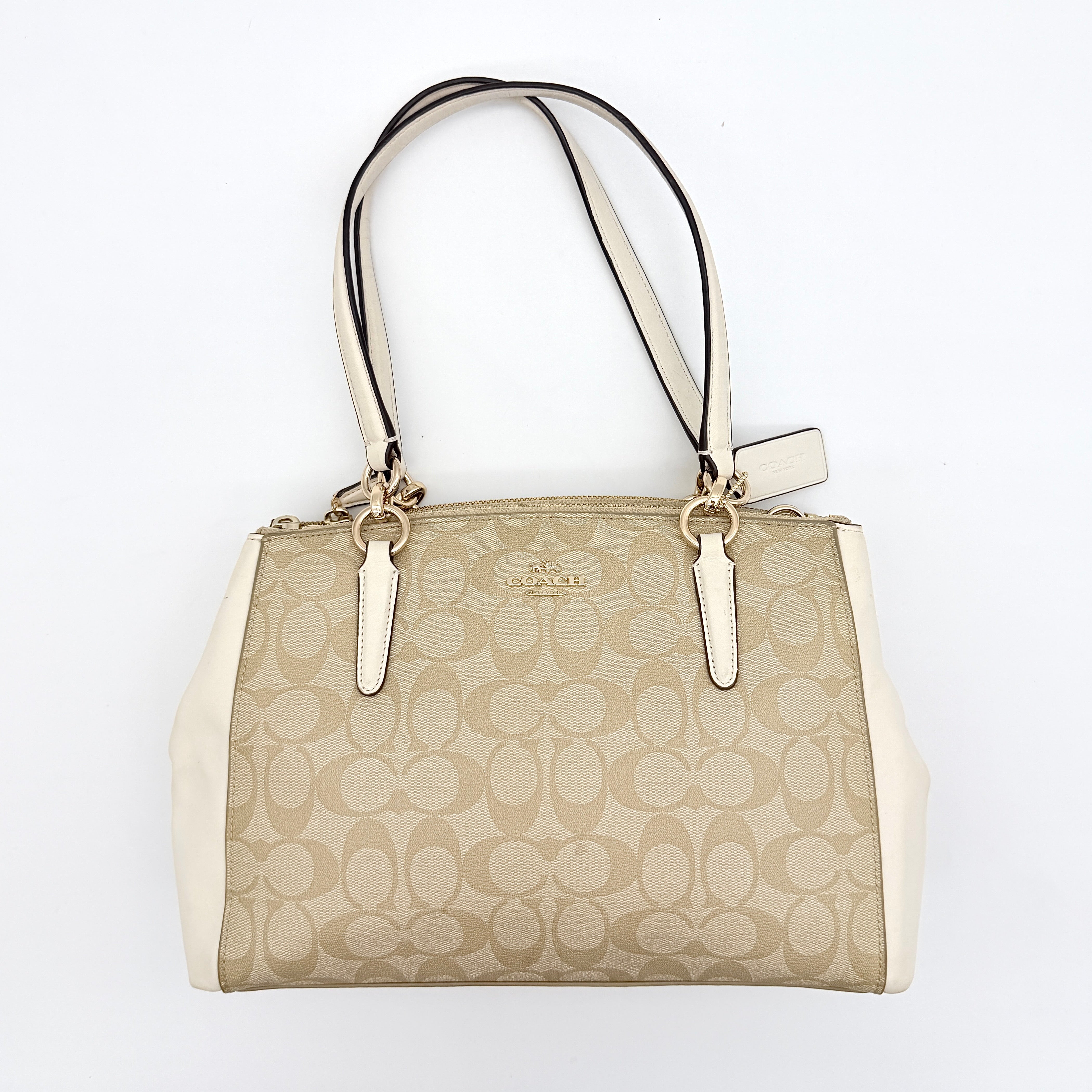 Coach Signature Christie Carryall in beige jacquard with white leather panels, double handles, and detachable strap.