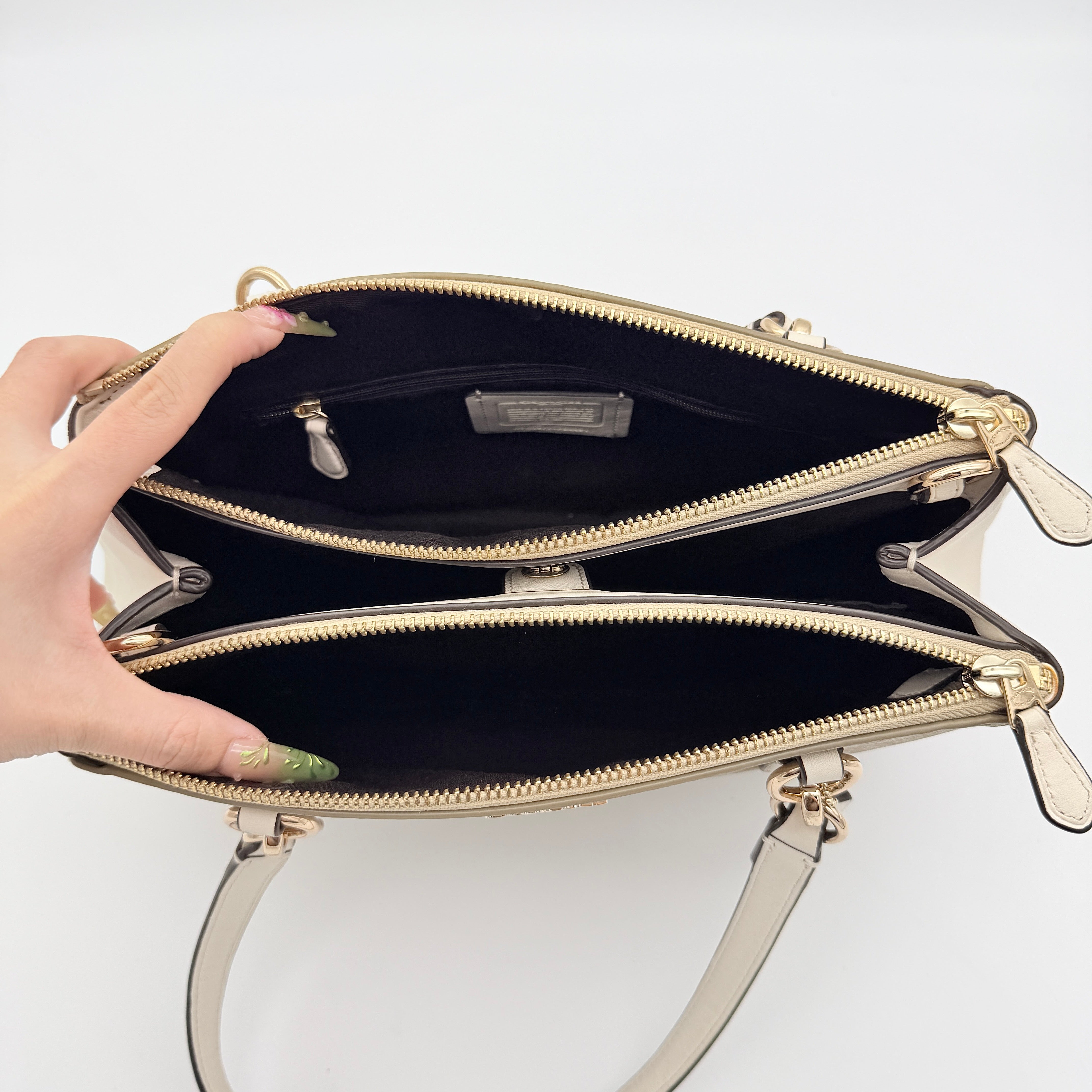 Coach Signature Christie Carryall in beige jacquard with white leather panels, double handles, and detachable strap.