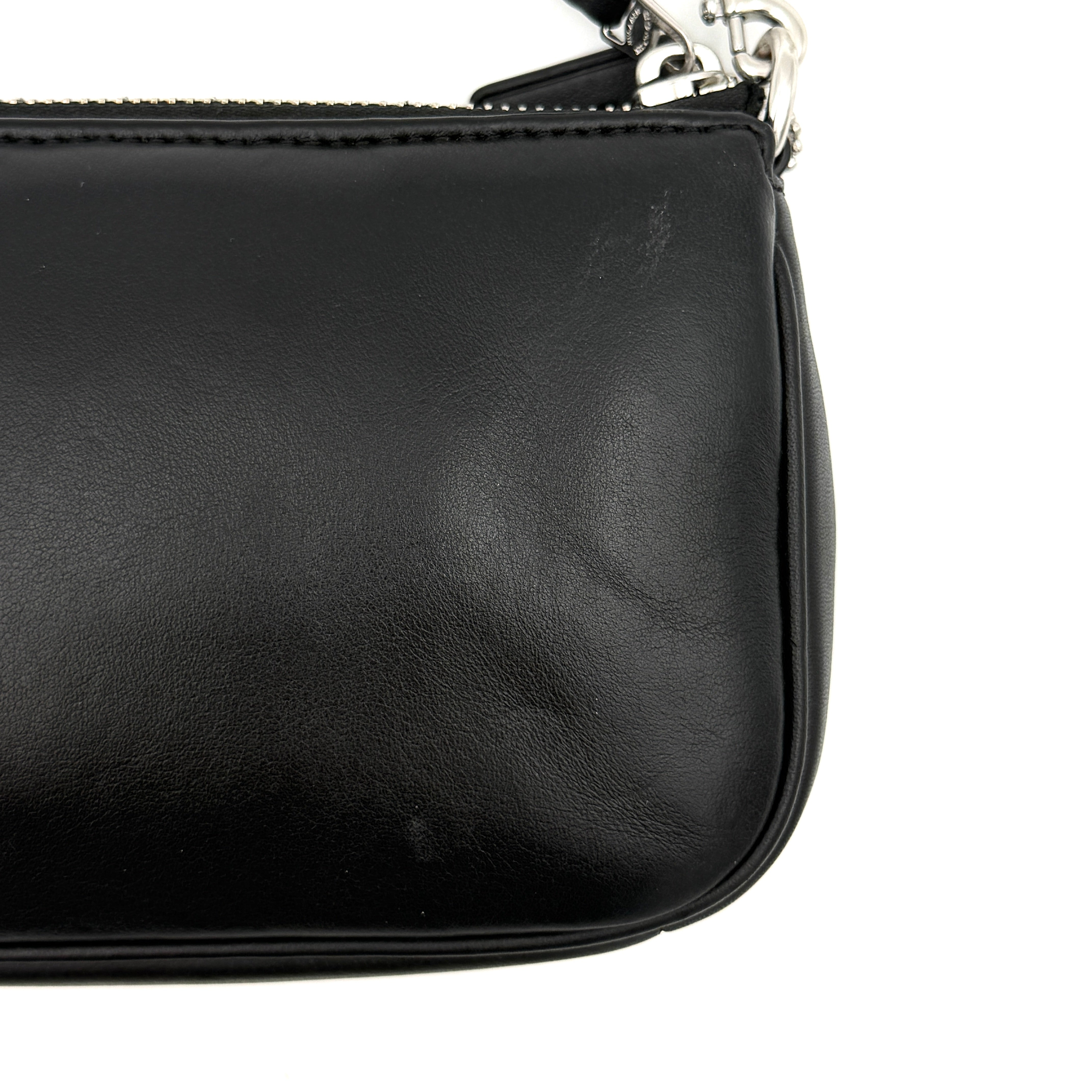 Coach Nolita 19 shoulder bag in quilted black leather with a bold stitched 'C' emblem and chunky silver chain strap.