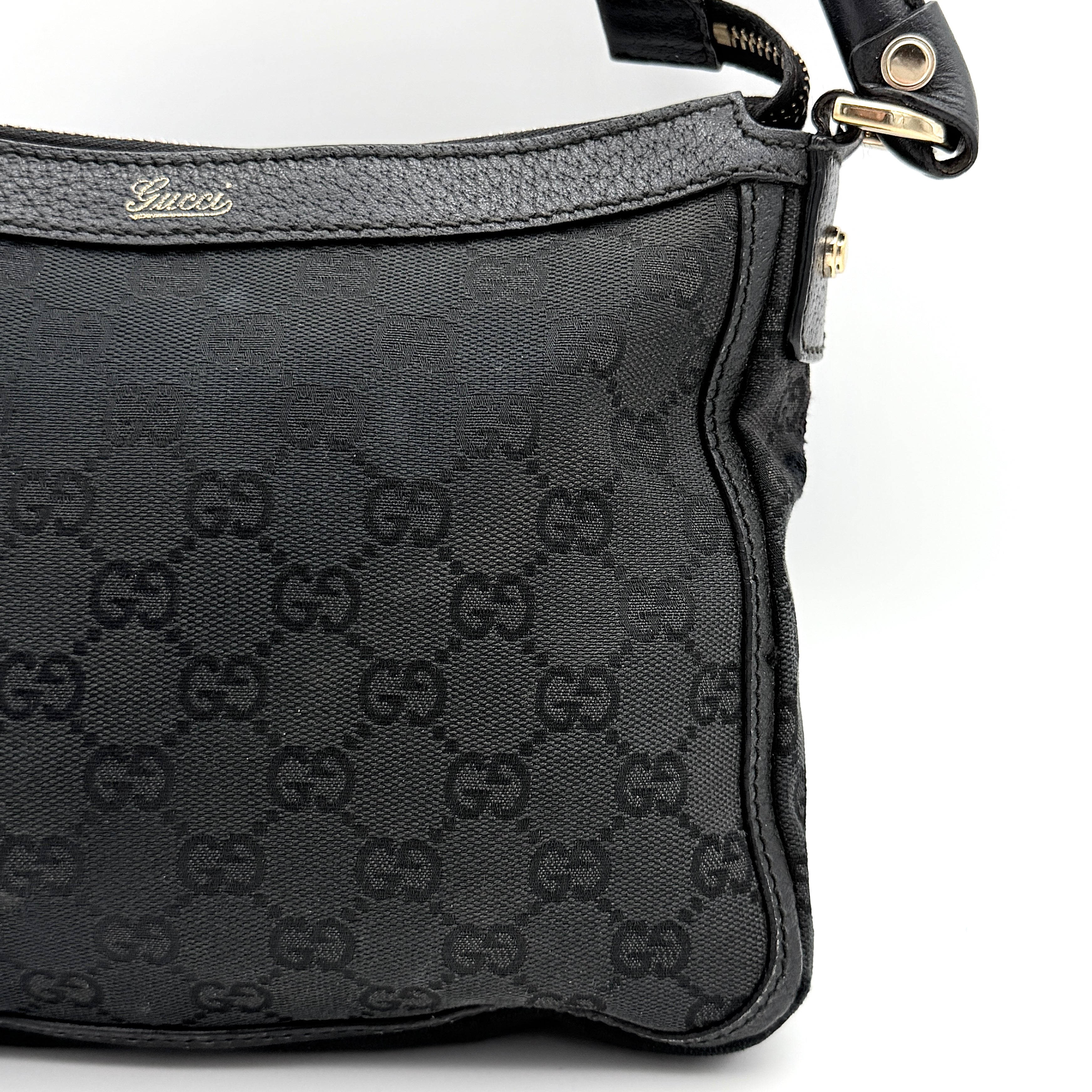 Front view of the Gucci GG Monogram Abbey Shoulder Bag in black with curved handle and gold hardware.