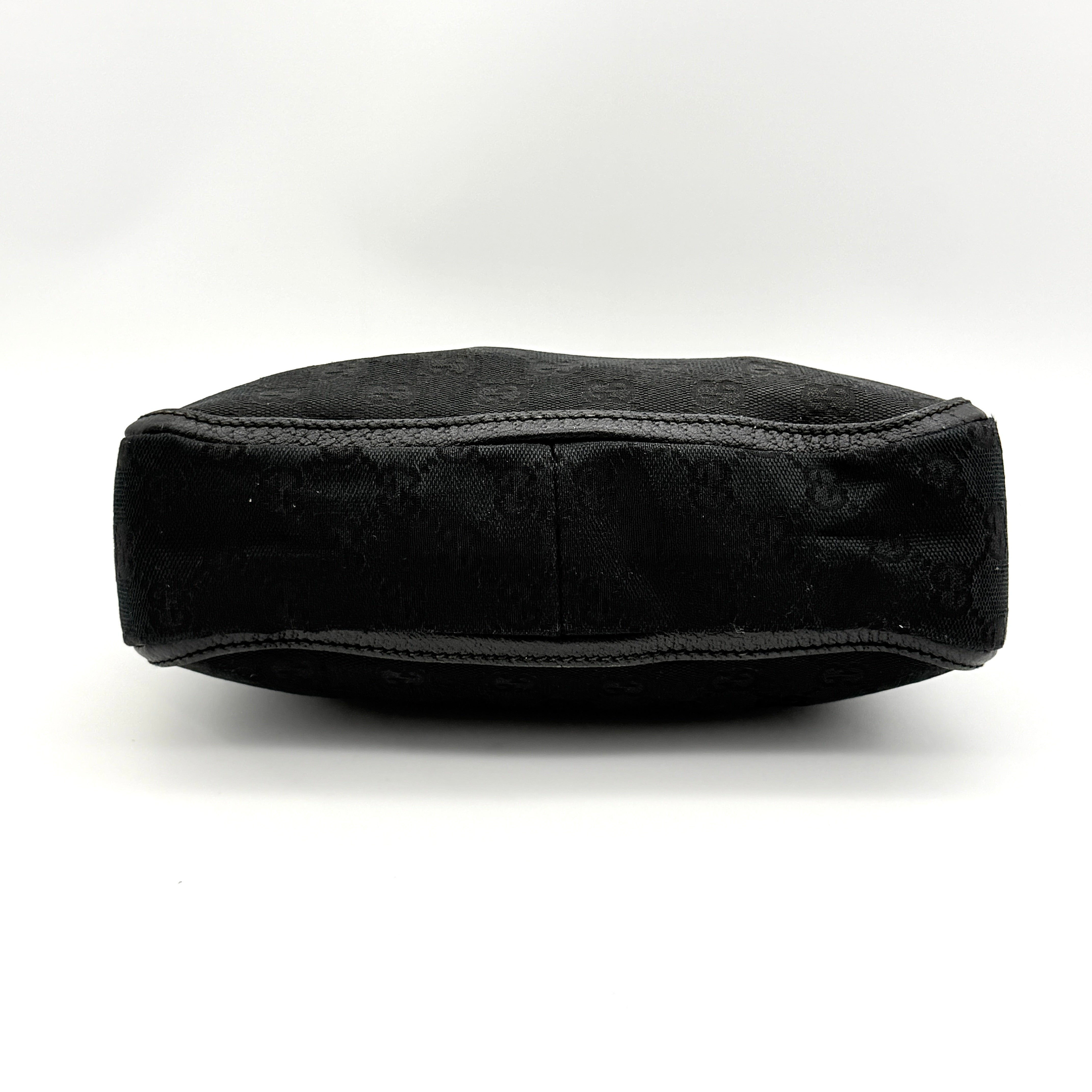 Front view of the Gucci GG Monogram Abbey Shoulder Bag in black with curved handle and gold hardware.