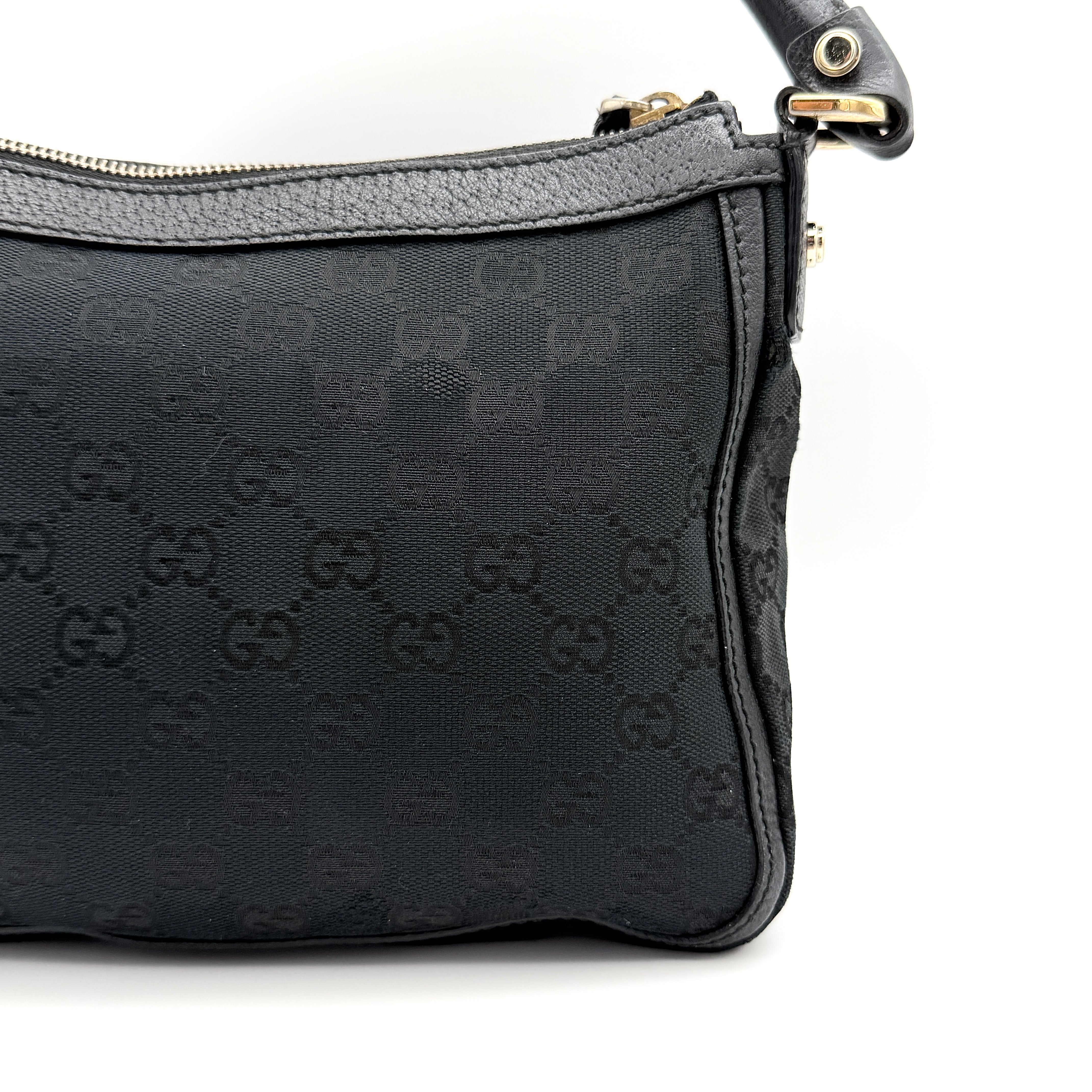 Front view of the Gucci GG Monogram Abbey Shoulder Bag in black with curved handle and gold hardware.