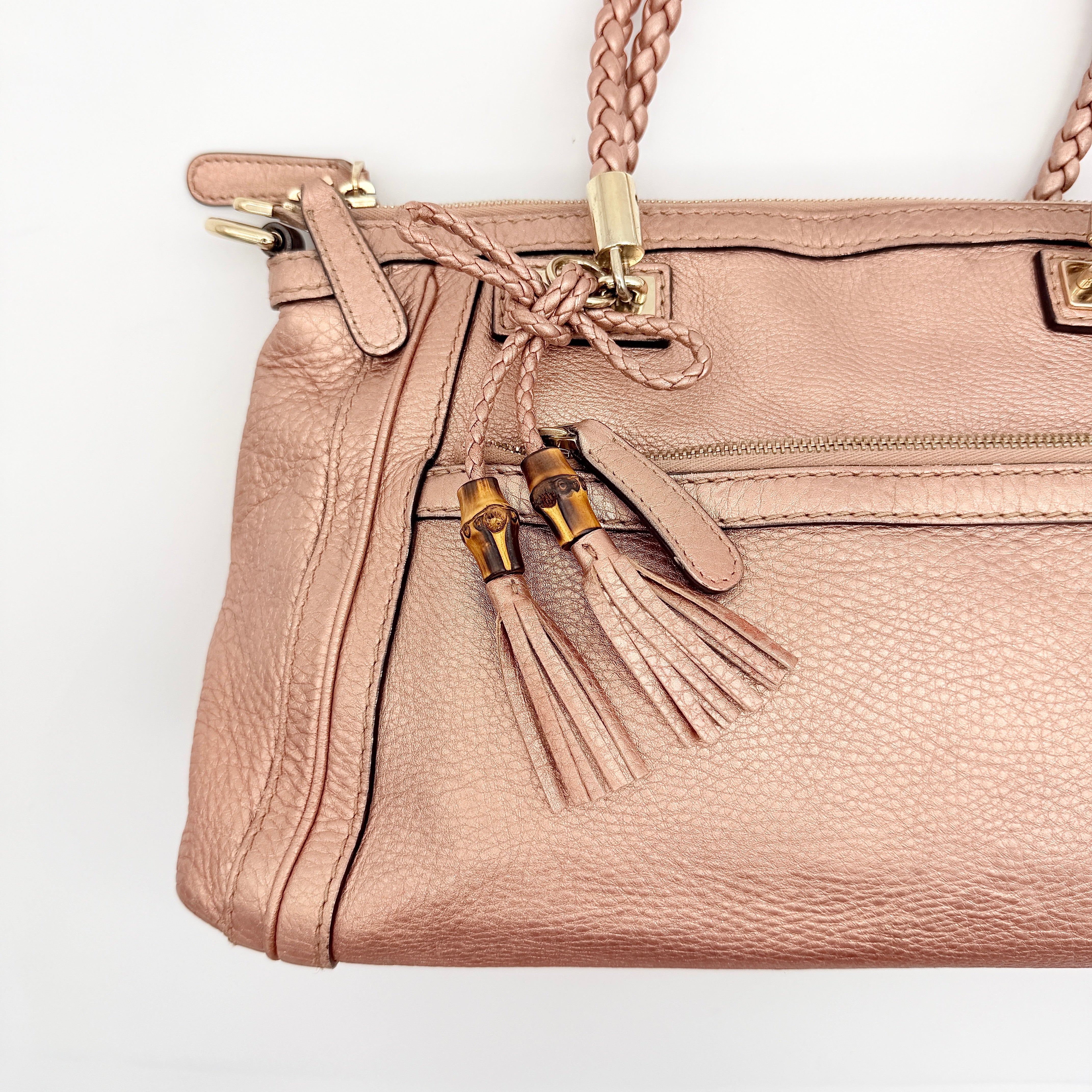 Gucci Bella Bamboo 2Way shoulder bag in metallic pink leather with braided handles and bamboo tassel accents, displayed with a detachable strap.