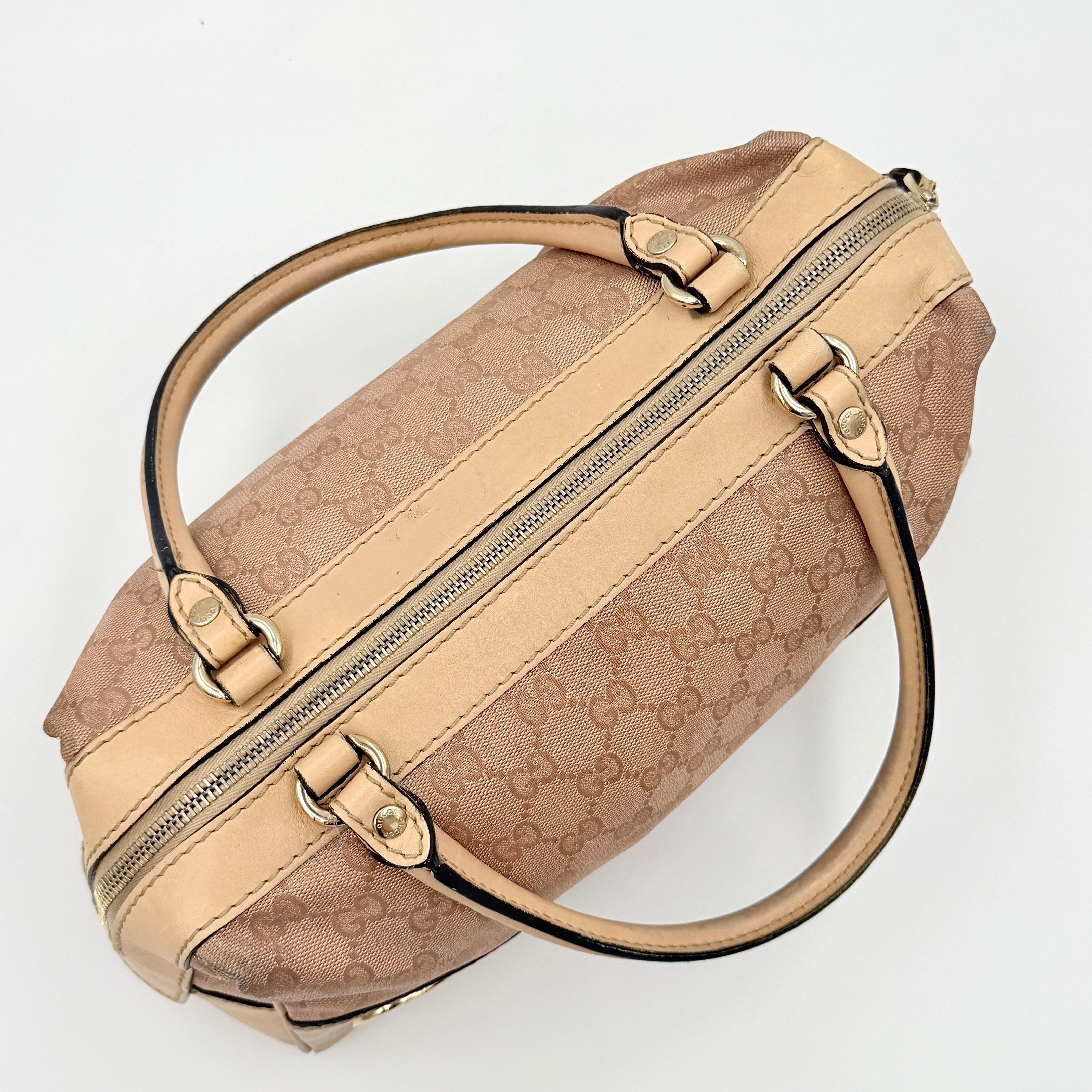 Gucci GG Monogram Heart Lovely Boston Bag in beige and pink with gold heart logo and double handles, displayed against a plain background.