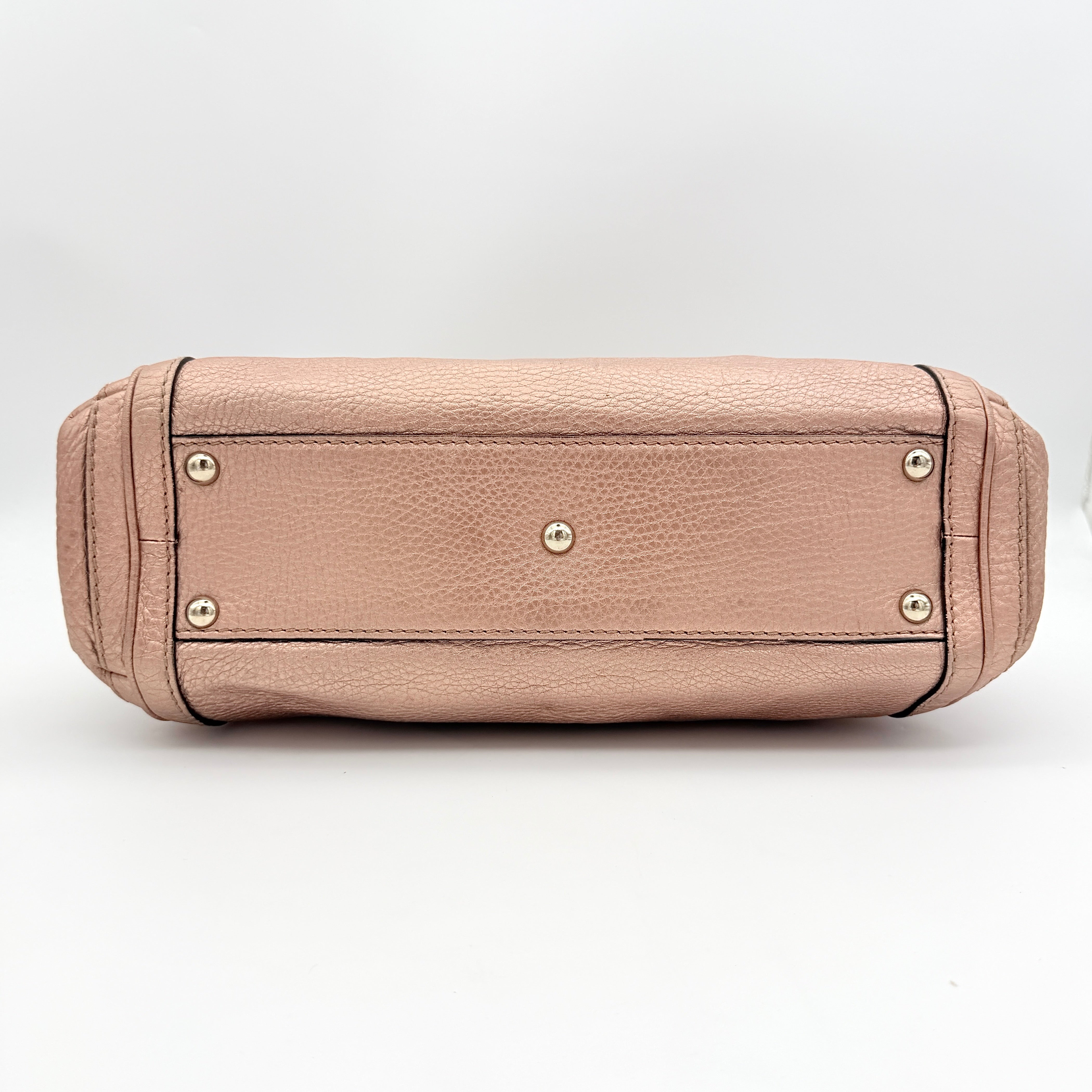 Gucci Bella Bamboo 2Way shoulder bag in metallic pink leather with braided handles and bamboo tassel accents, displayed with a detachable strap.