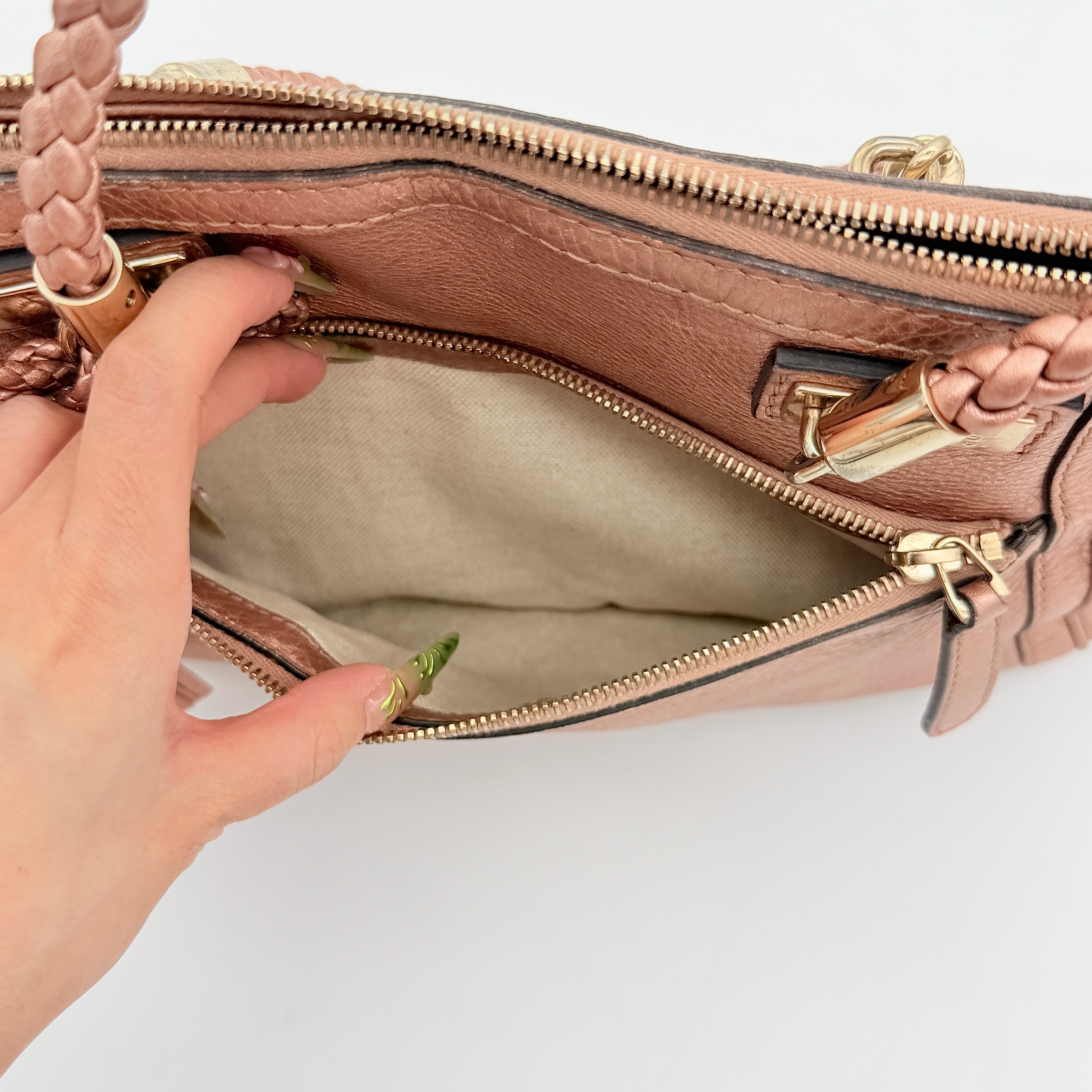 Gucci Bella Bamboo 2Way shoulder bag in metallic pink leather with braided handles and bamboo tassel accents, displayed with a detachable strap.