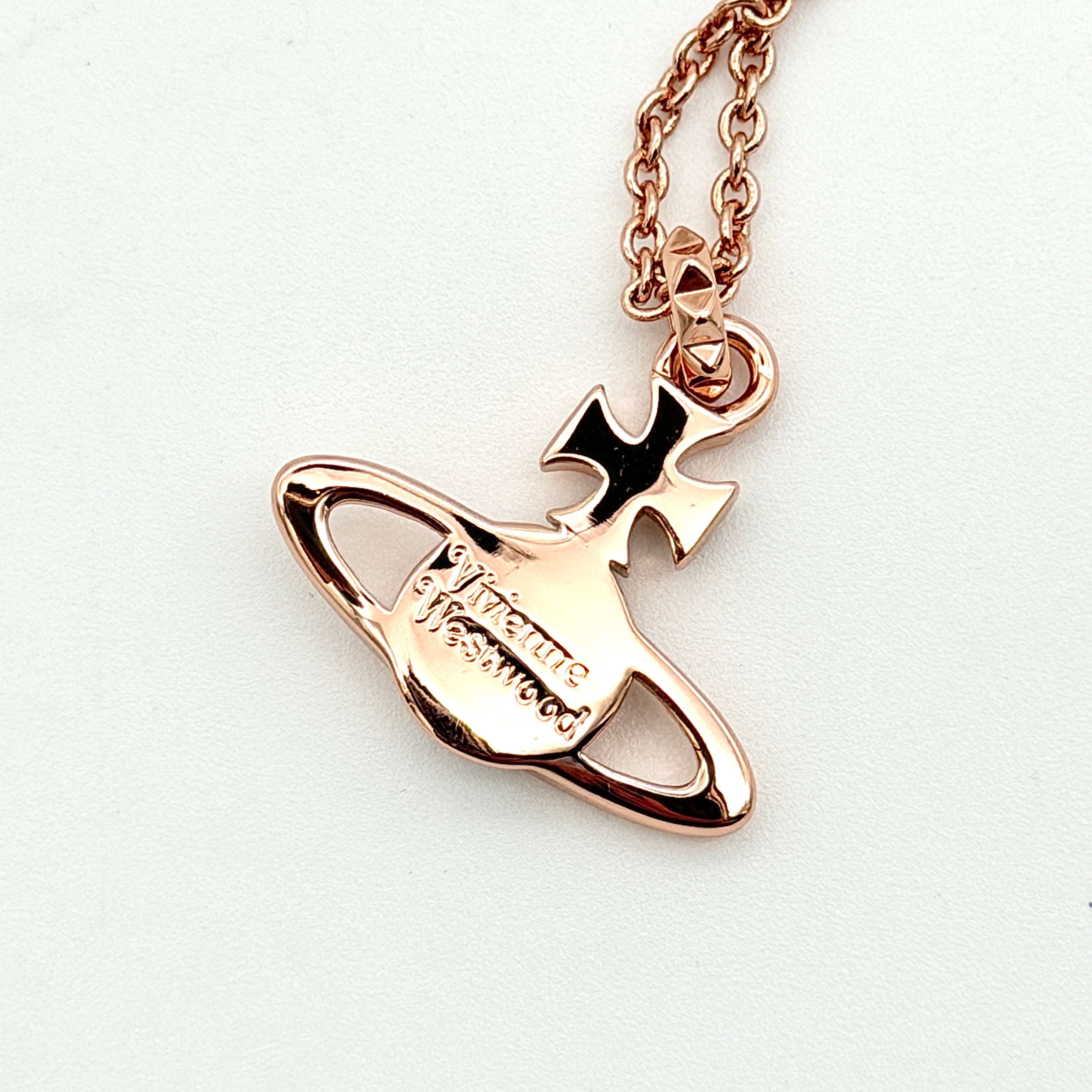Vivienne Westwood rose gold Orb necklace with rhinestone accents displayed on a white background.