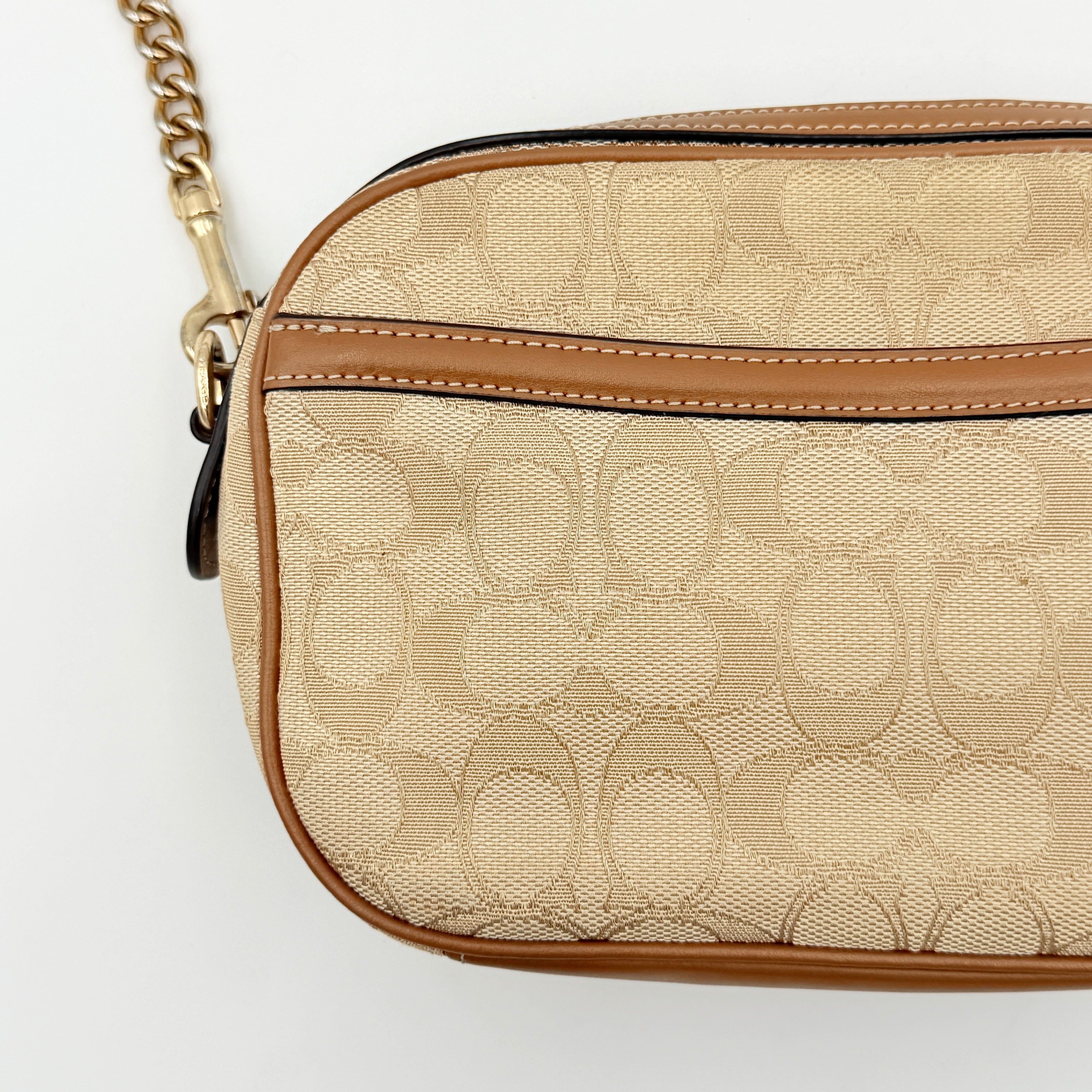 Coach Signature Isla Chain Crossbody Bag in beige and brown jacquard with caramel leather trim and gold-tone chain strap.
