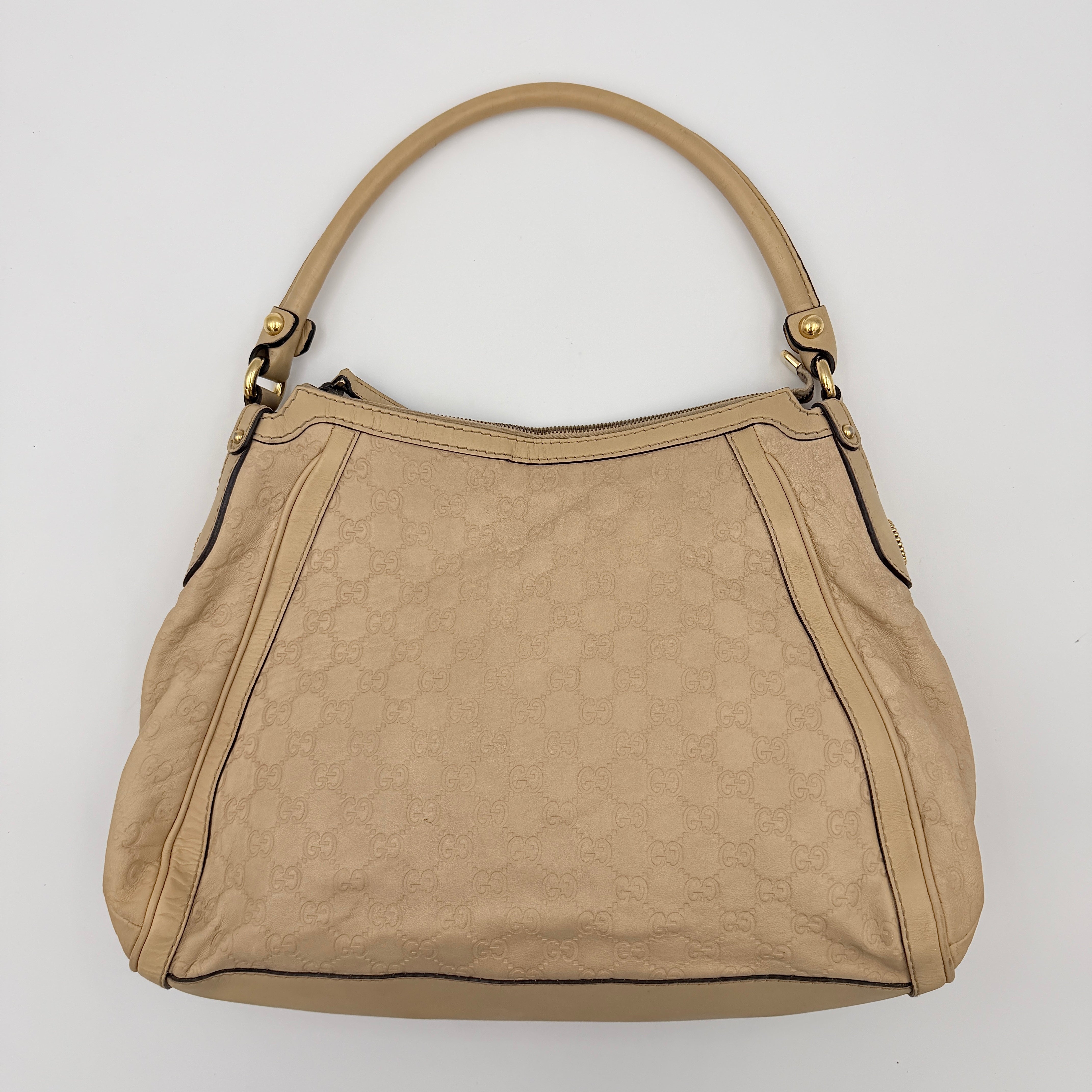 Gucci GG Monogram Guccissima Scarlett Shoulder Bag in beige embossed leather with gold hardware and single top handle.