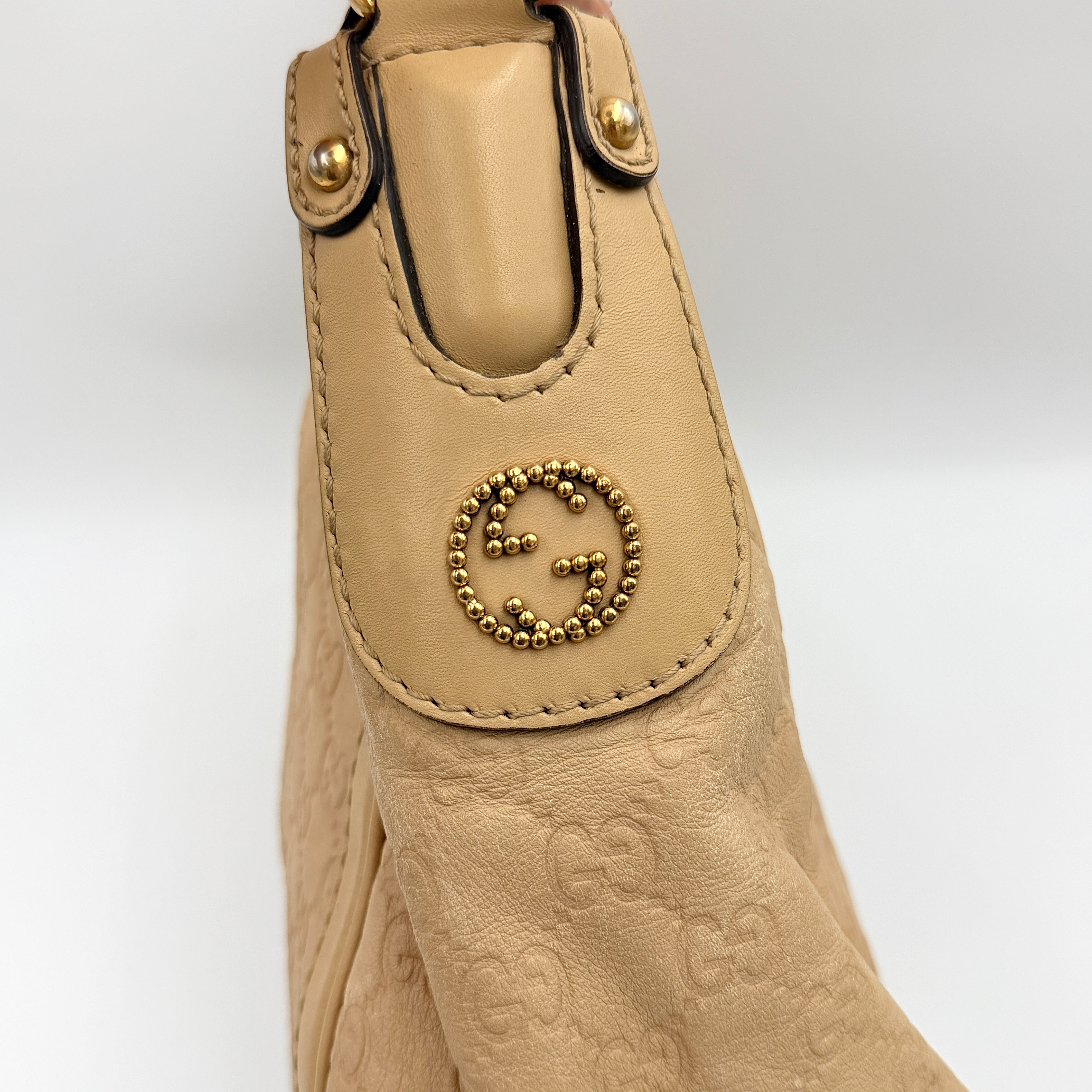Gucci GG Monogram Guccissima Scarlett Shoulder Bag in beige embossed leather with gold hardware and single top handle.
