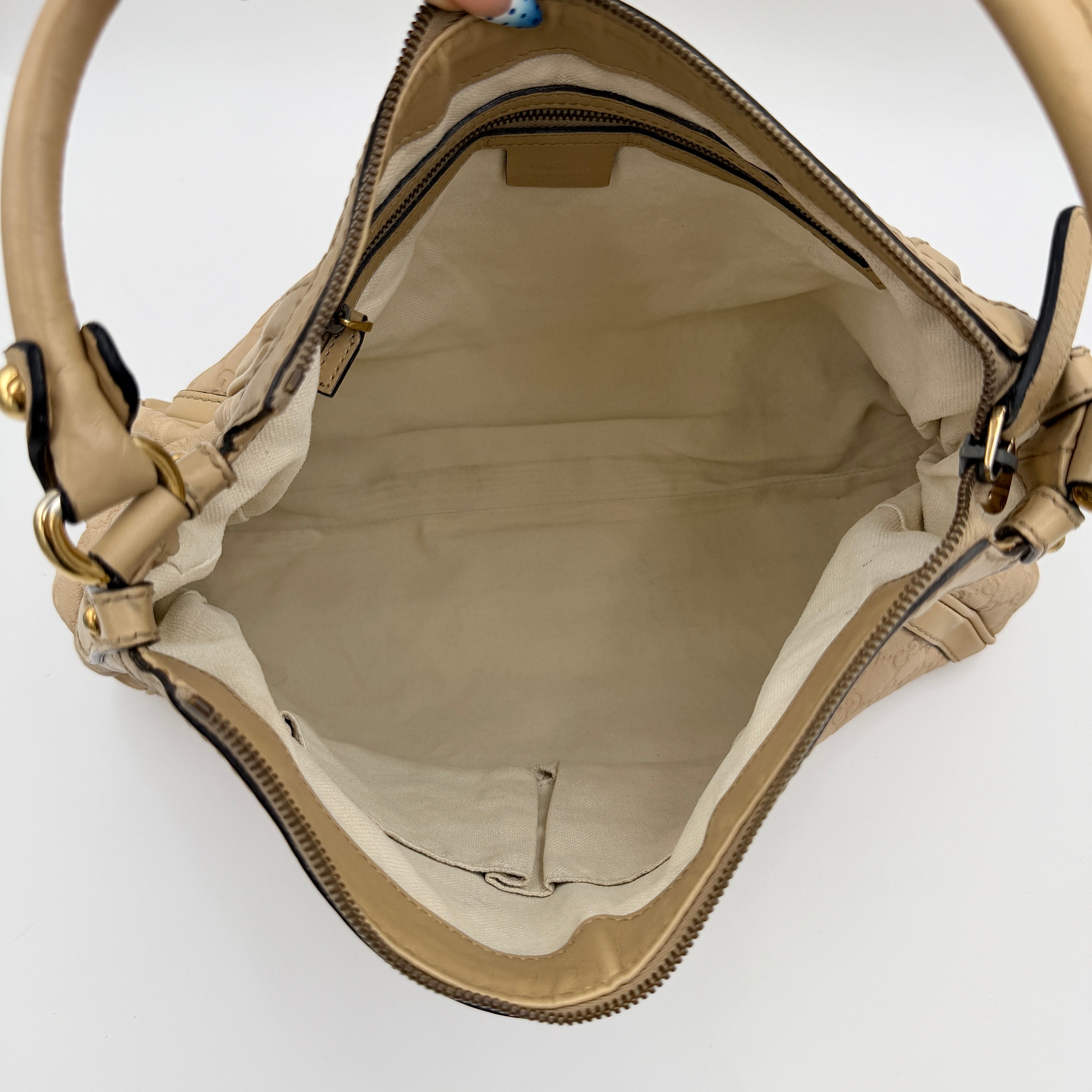 Gucci GG Monogram Guccissima Scarlett Shoulder Bag in beige embossed leather with gold hardware and single top handle.