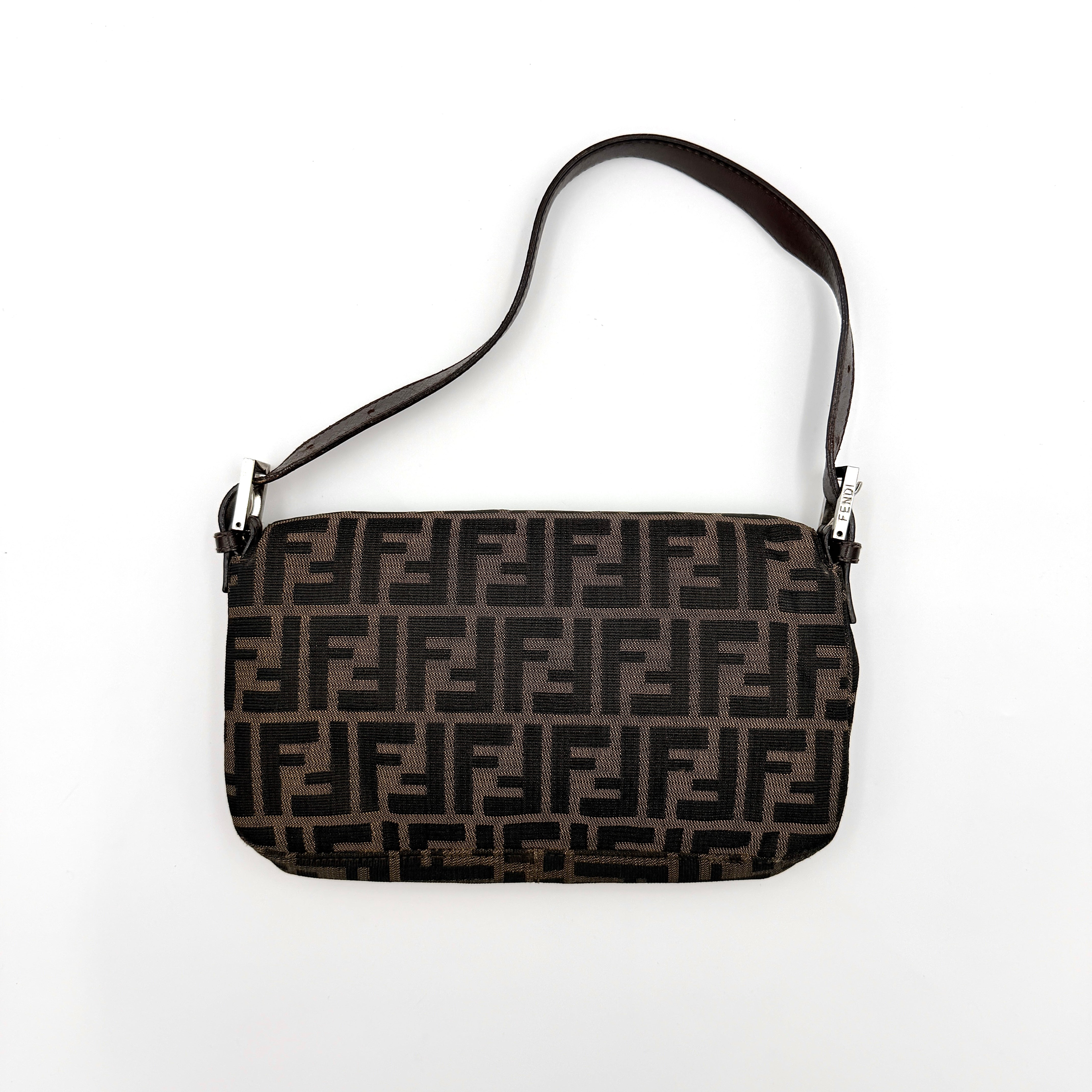 Fendi Zucca Print Baguette Bag in brown monogram canvas with silver-tone FF clasp and leather trim shown against a white background.