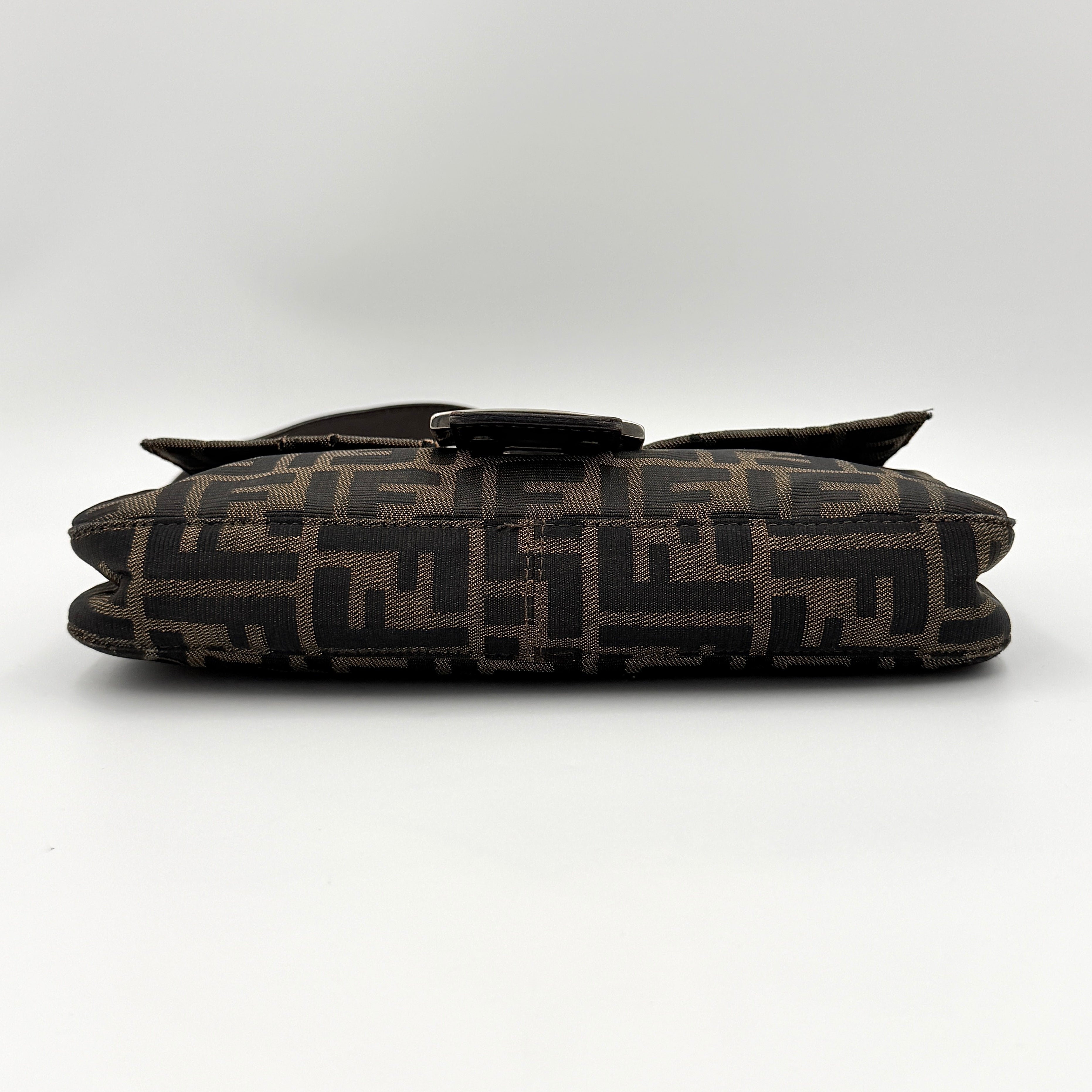 Fendi Zucca Print Baguette Bag in brown monogram canvas with silver-tone FF clasp and leather trim shown against a white background.