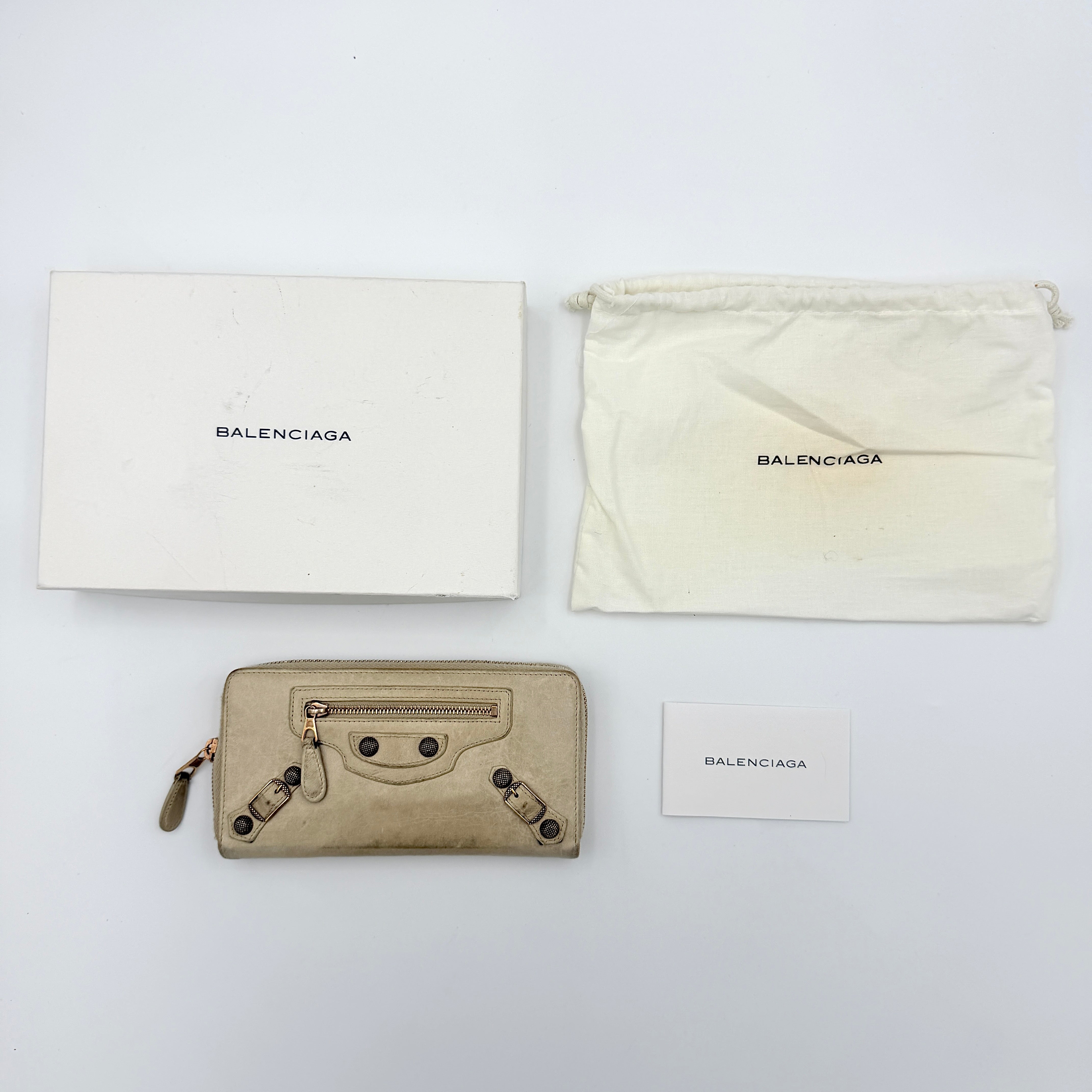 Balenciaga Motorcycle Studded Long Wallet in beige leather with signature studs and front zip pocket, displayed against a clean background.