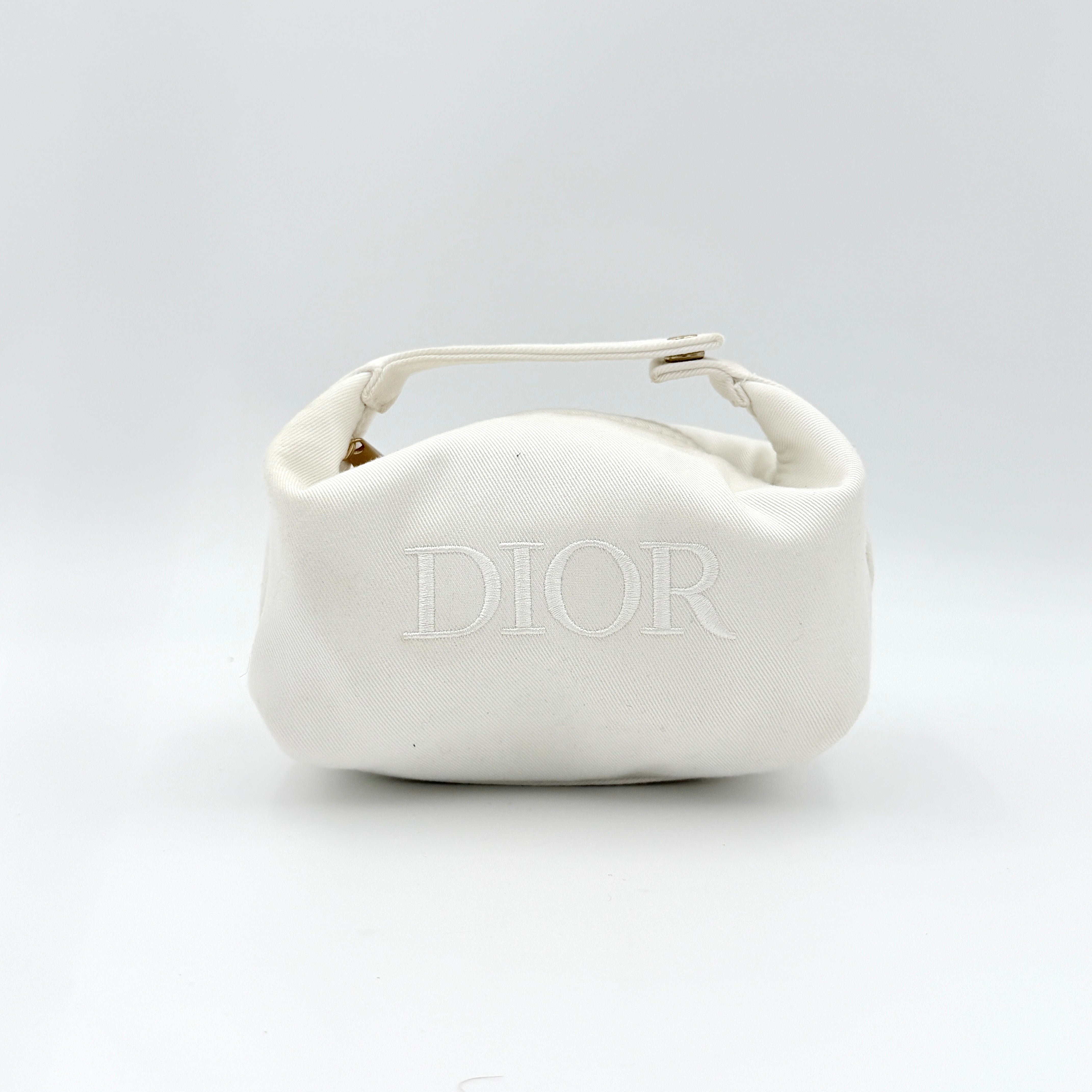 A structured white Dior pouch in twill with tonal logo embroidery and gold-tone zip, displayed against a pristine backdrop.