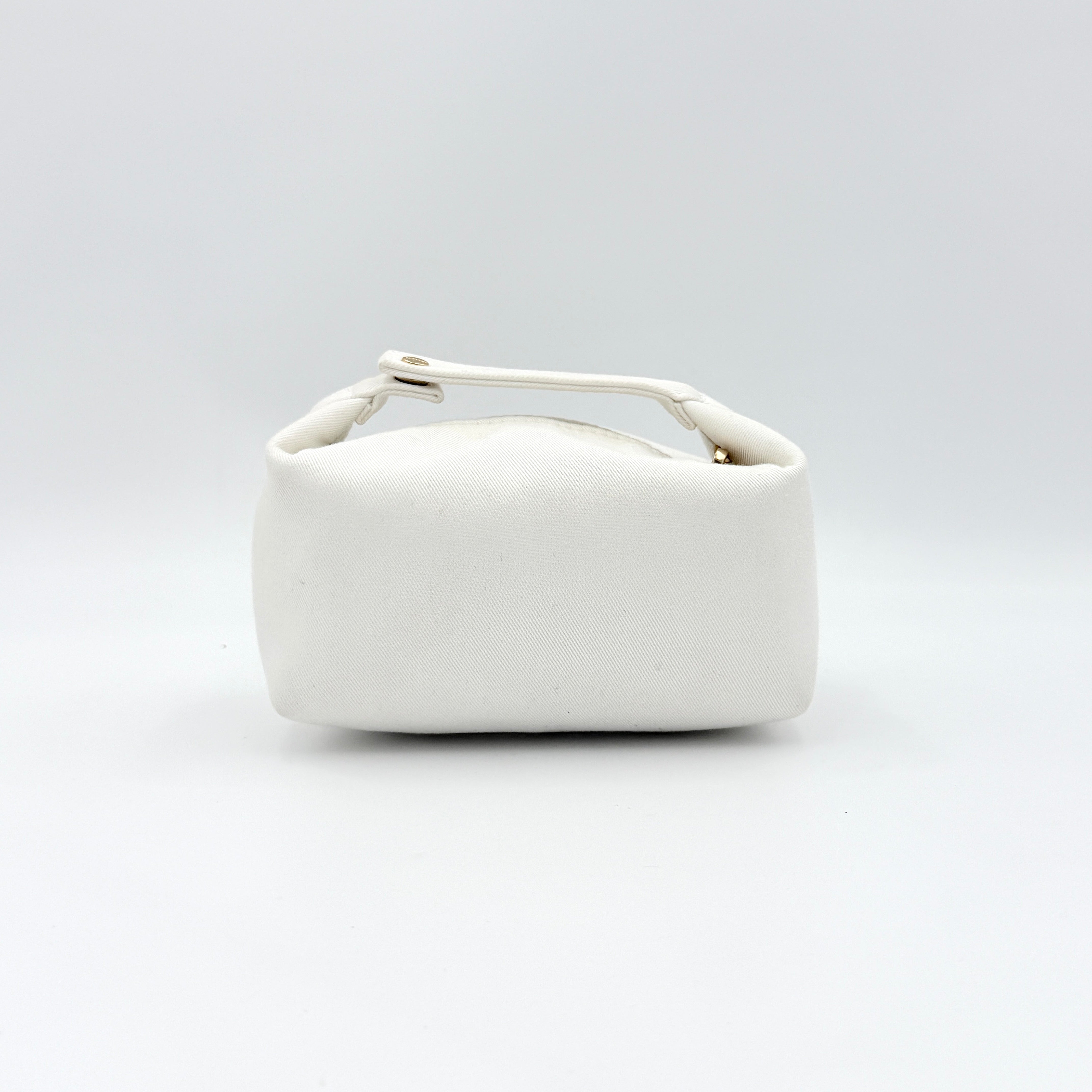 A structured white Dior pouch in twill with tonal logo embroidery and gold-tone zip, displayed against a pristine backdrop.