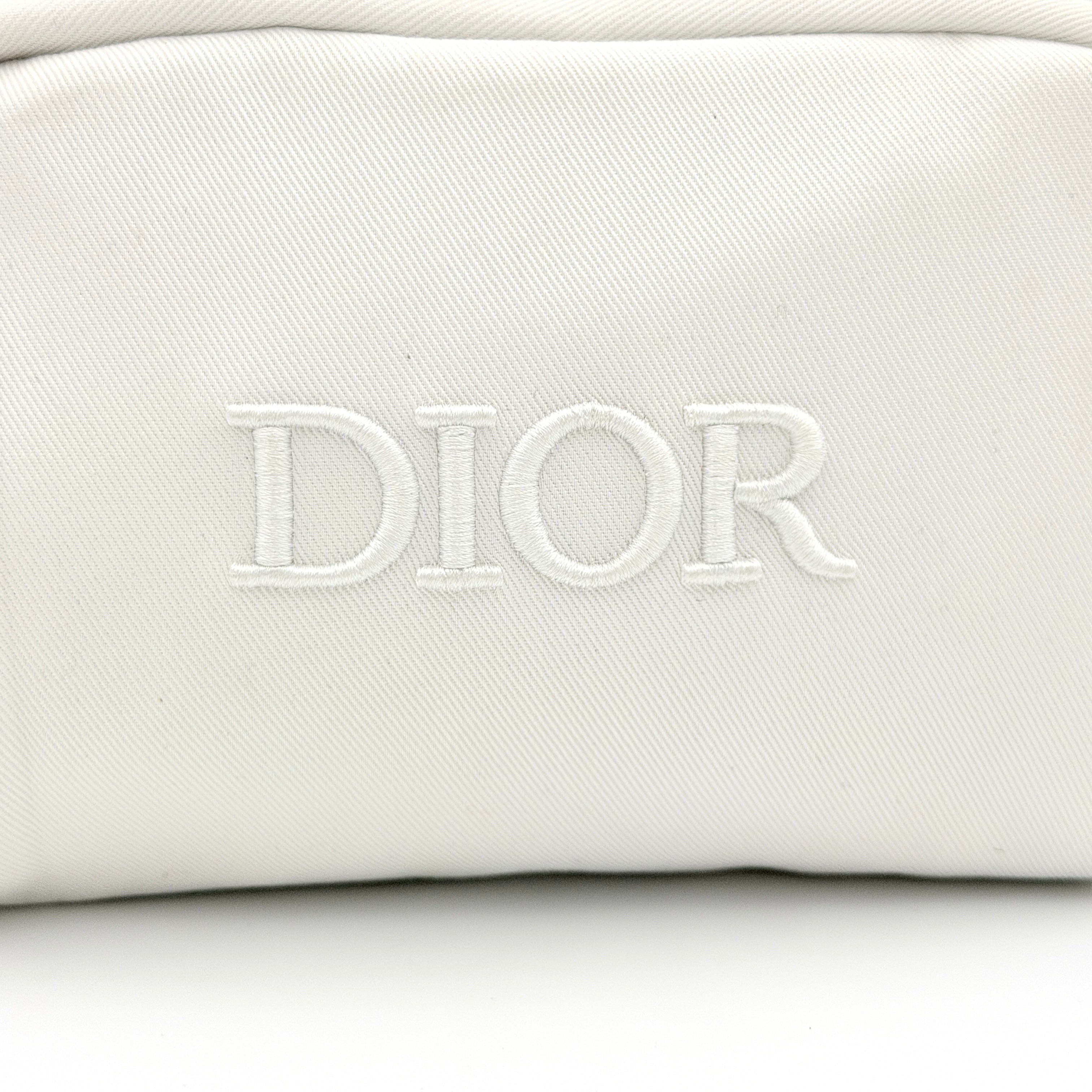 Crisp white Dior Beauty Logo Pouch with an embroidered logo and sleek silver-tone zipper, showcased against a minimalist backdrop.