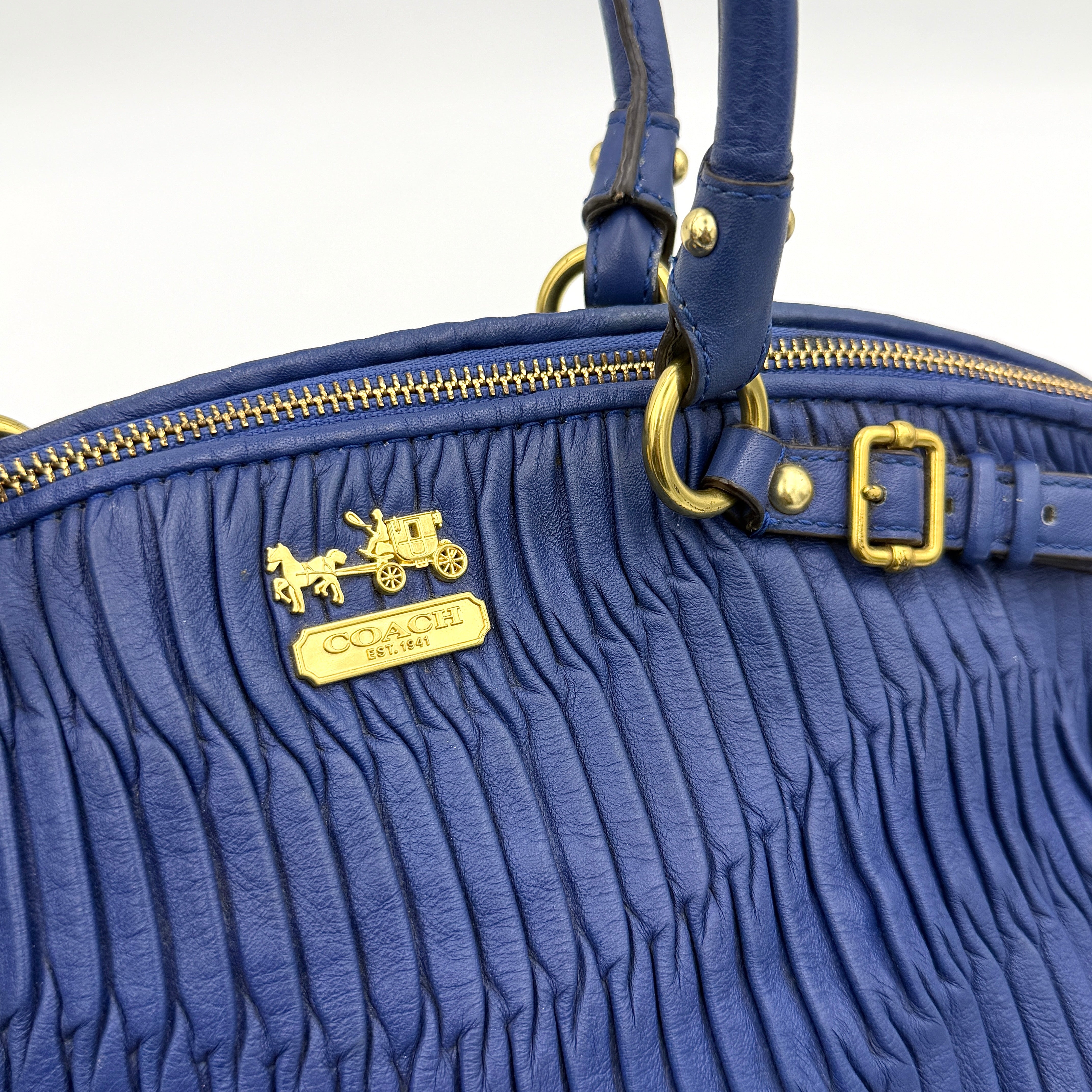 Coach Madison Shoulder Bag in gathered blue leather with gold-tone hardware and removable shoulder strap displayed against a white backdrop.
